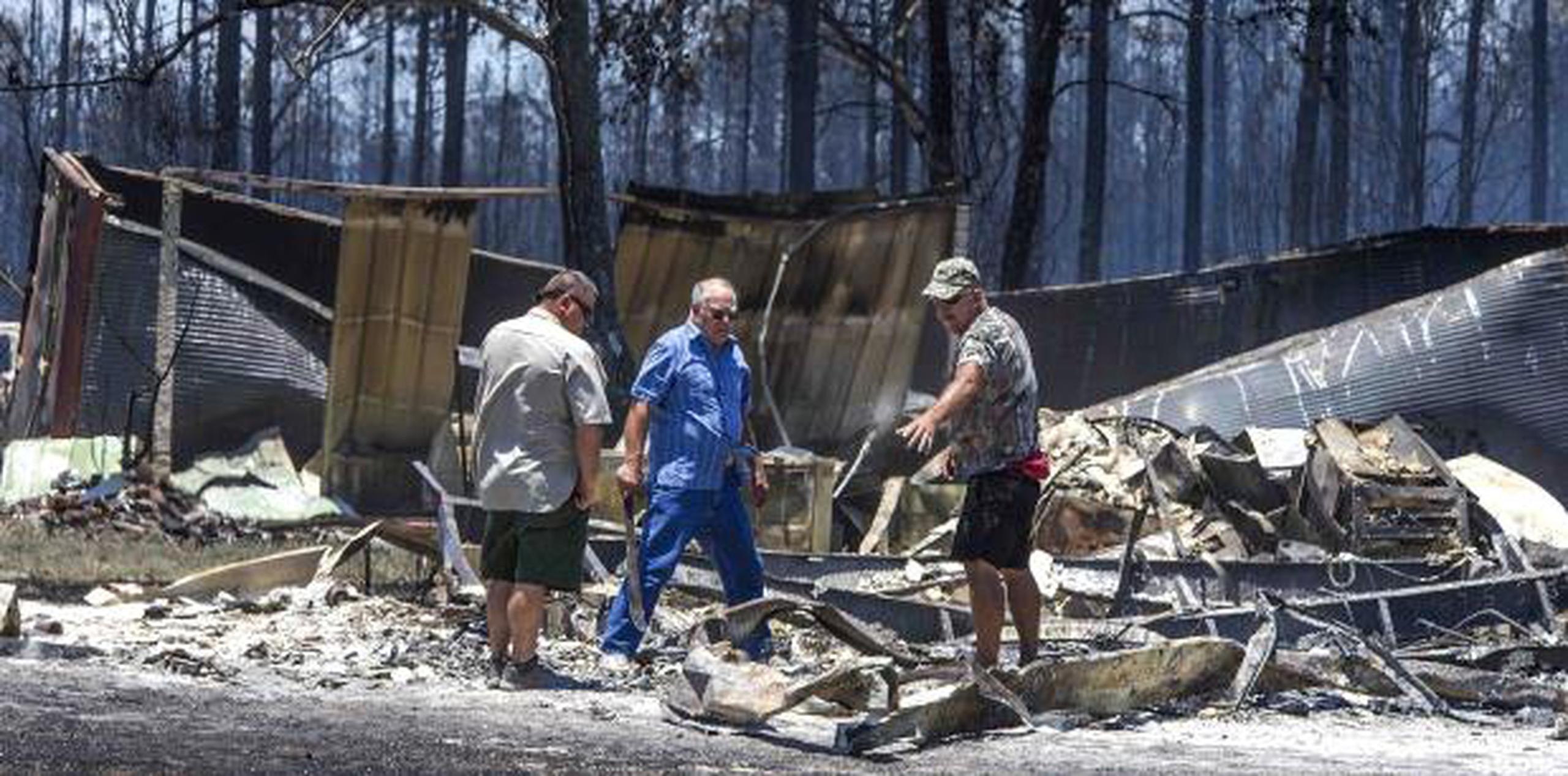Residentes rescatan sus pertenencias de sus casas quemadas en Eastpoint, Florida. (AP / Mark Wallheiser)