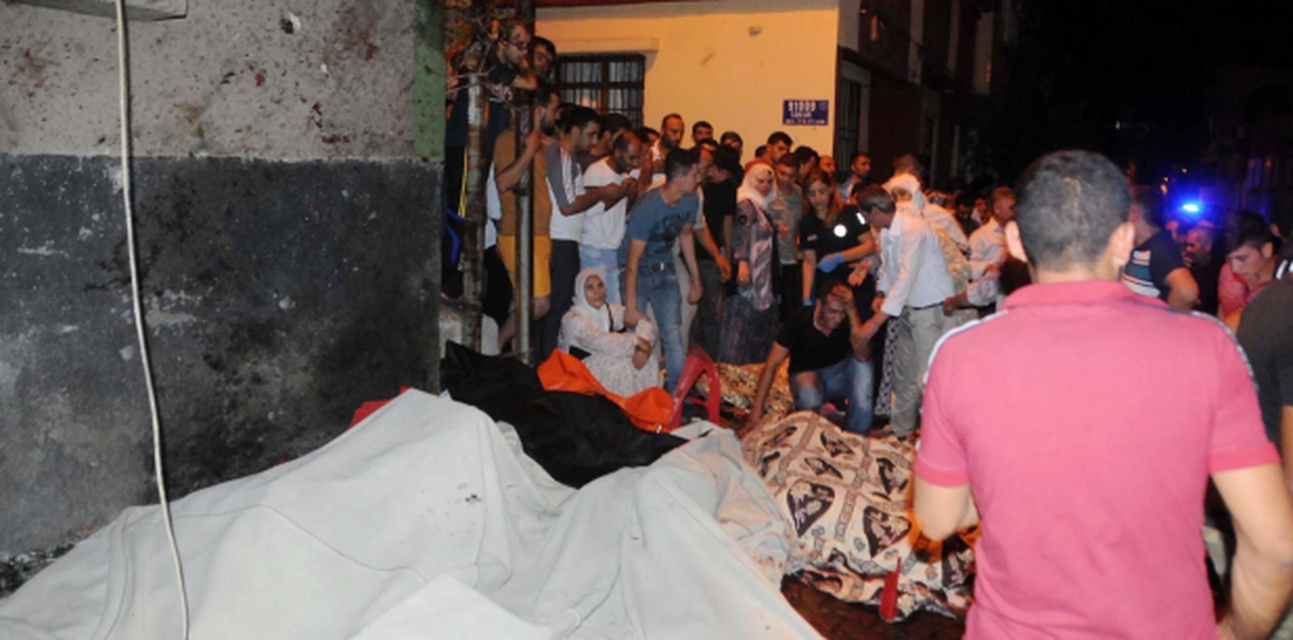 Una multitud observa varios de los cuerpos luego de la explosión en Gaziantep, en el sur de Turquía. (Eyyup Burun/DHA via AP)
