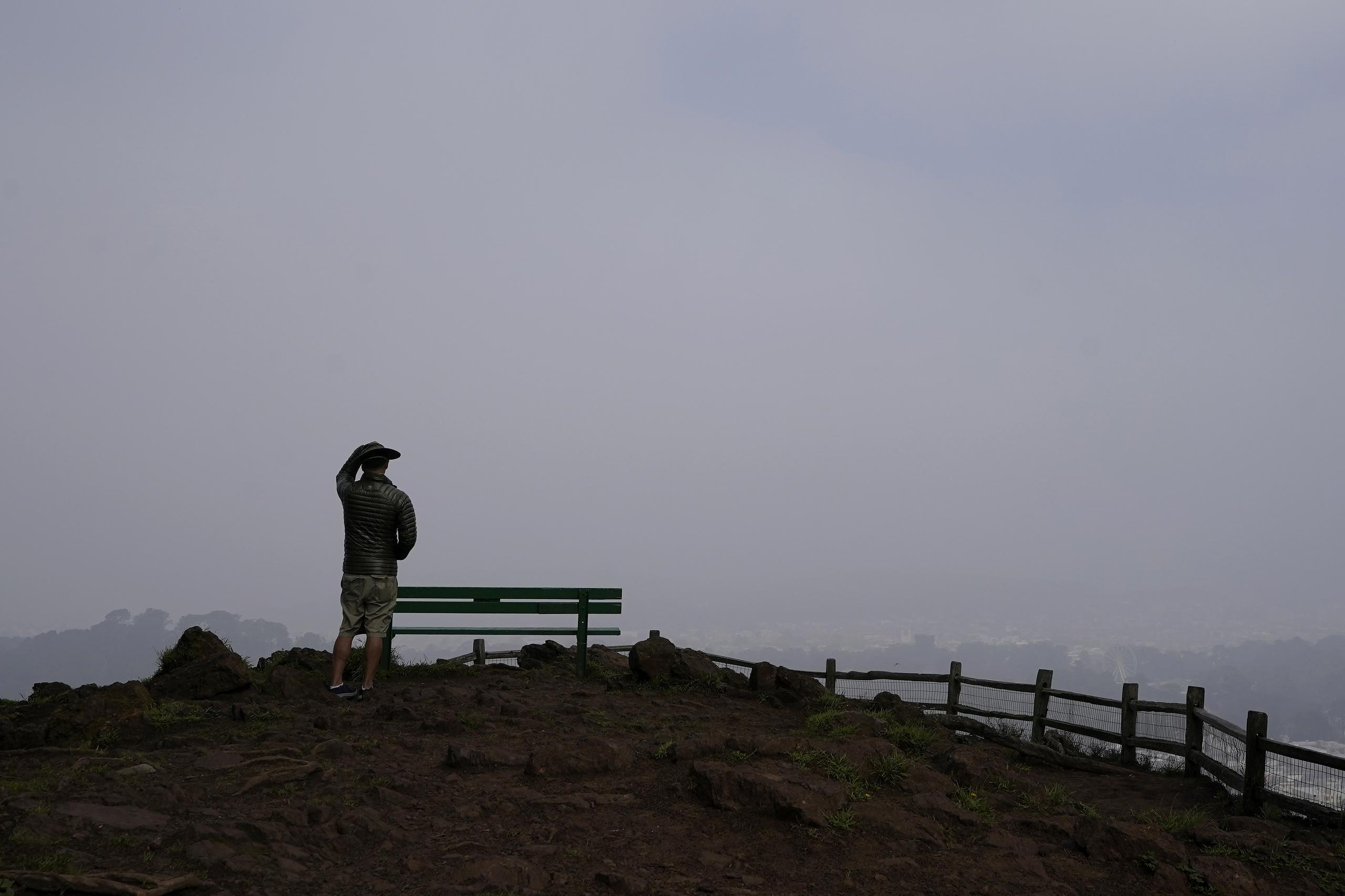 Un individuo observa desde un punto alto el Parque Grand View de San Francisco cubierto de smog por incendios forestales.