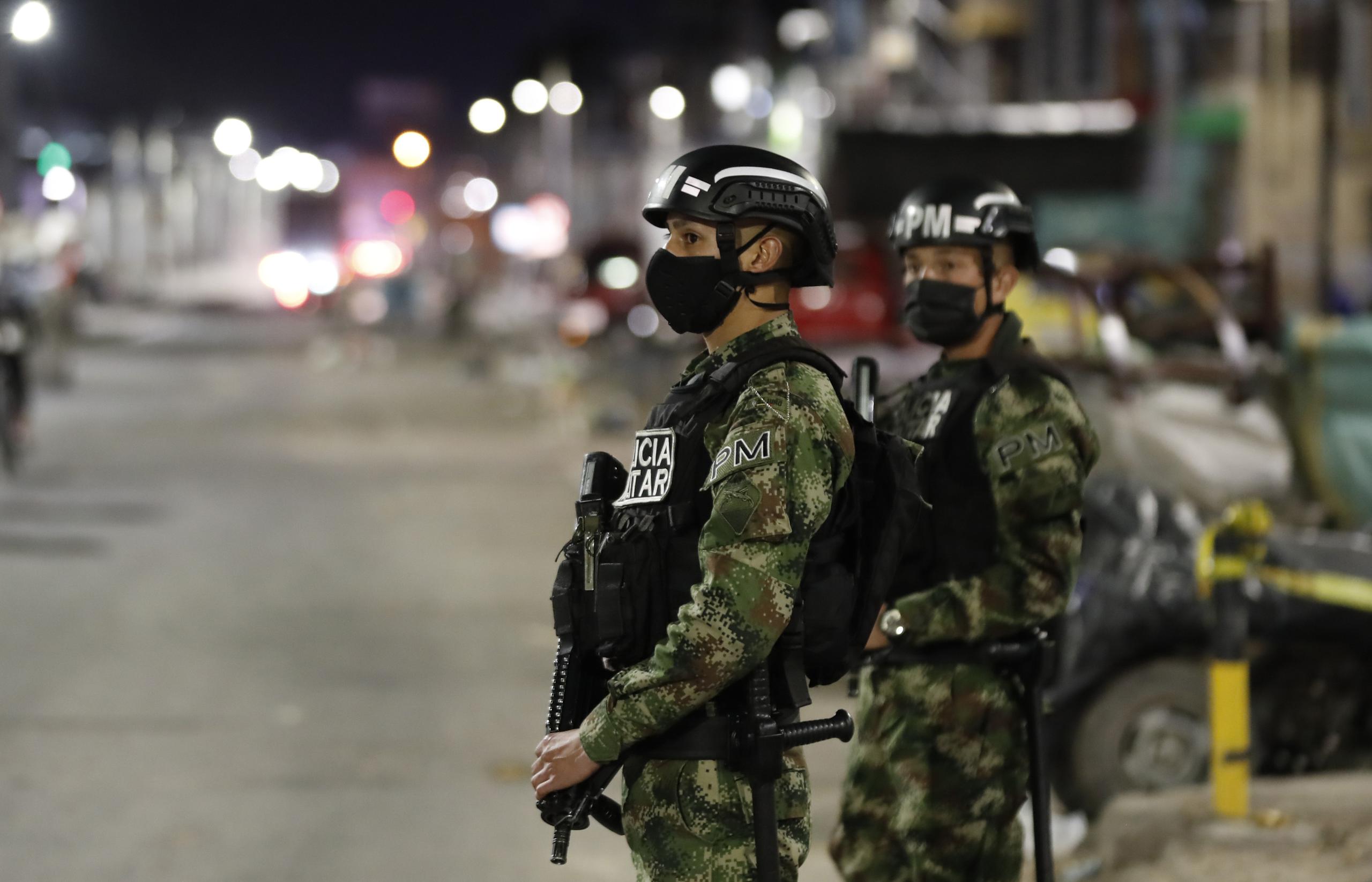 Soldados vigilan una calle durante el toque de queda impuesto hoy en Bogotá, Colombia.