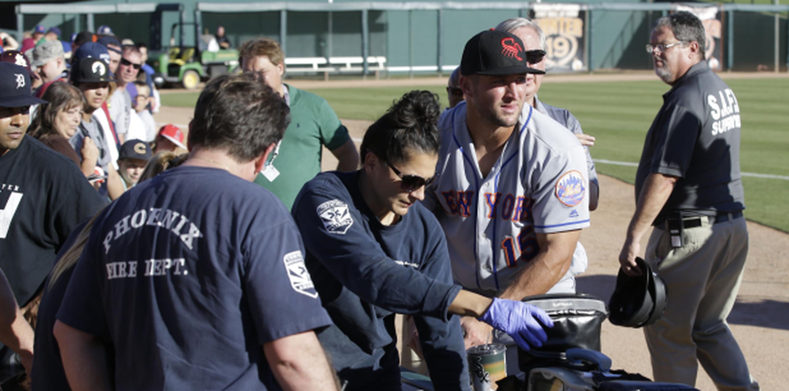 Tim Tebow se mantuvo junto al fanático que había sufrido el ataque hasta que los paramédicos se lo llevaron. (Rob Schumacher/The Arizona Republic via AP)

