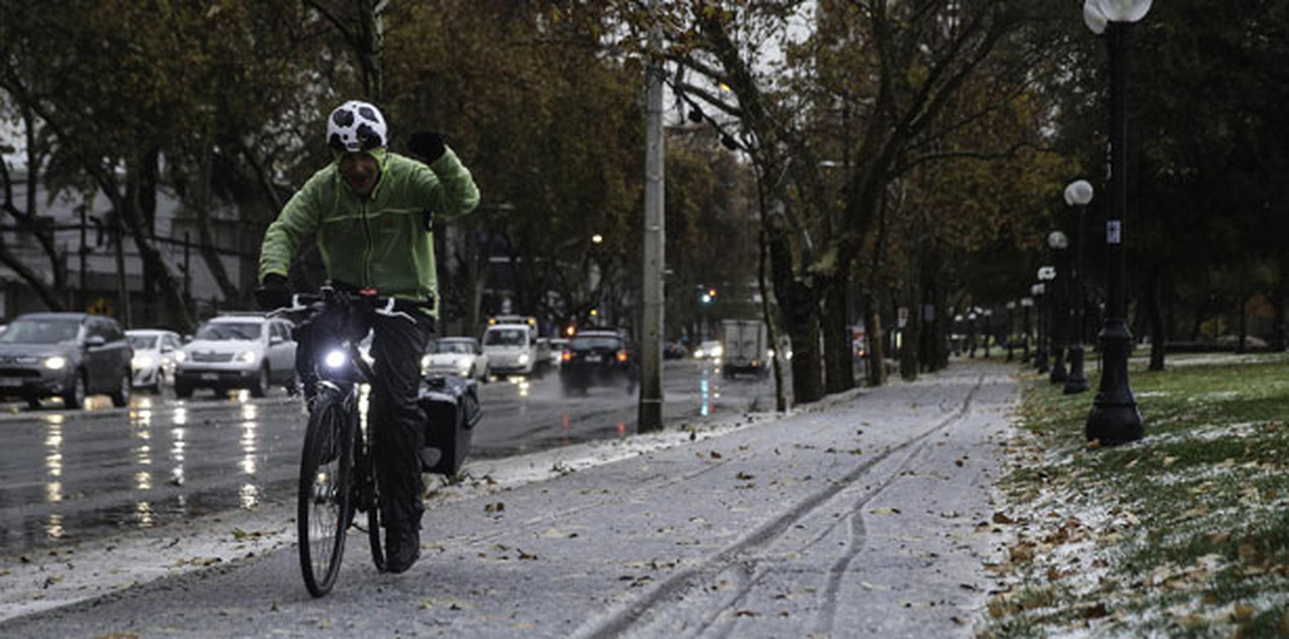 La nieve sorprendió a los viandantes en las calles de la capital chilena, quienes se apresuraron a tomar fotografías con sus teléfonos móviles de la estampa invernal. (EFE)