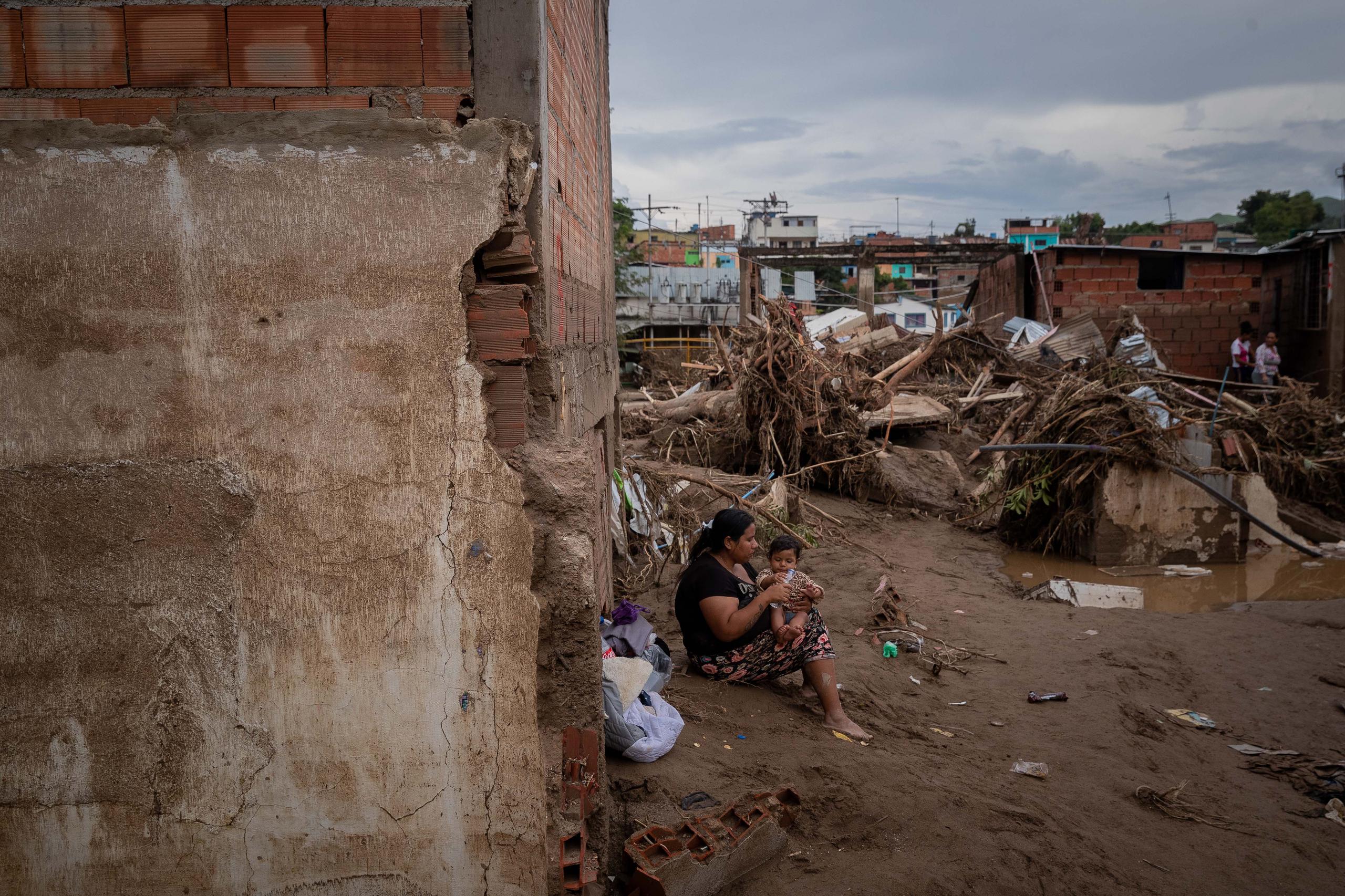Una mujer y su bebé fueron registrados frente a los estragos que dejó el desbordamiento de la quebrada Los Patos, en Las Tejerías (estado Aragua, Venezuela). EFE/Rayner Peña
