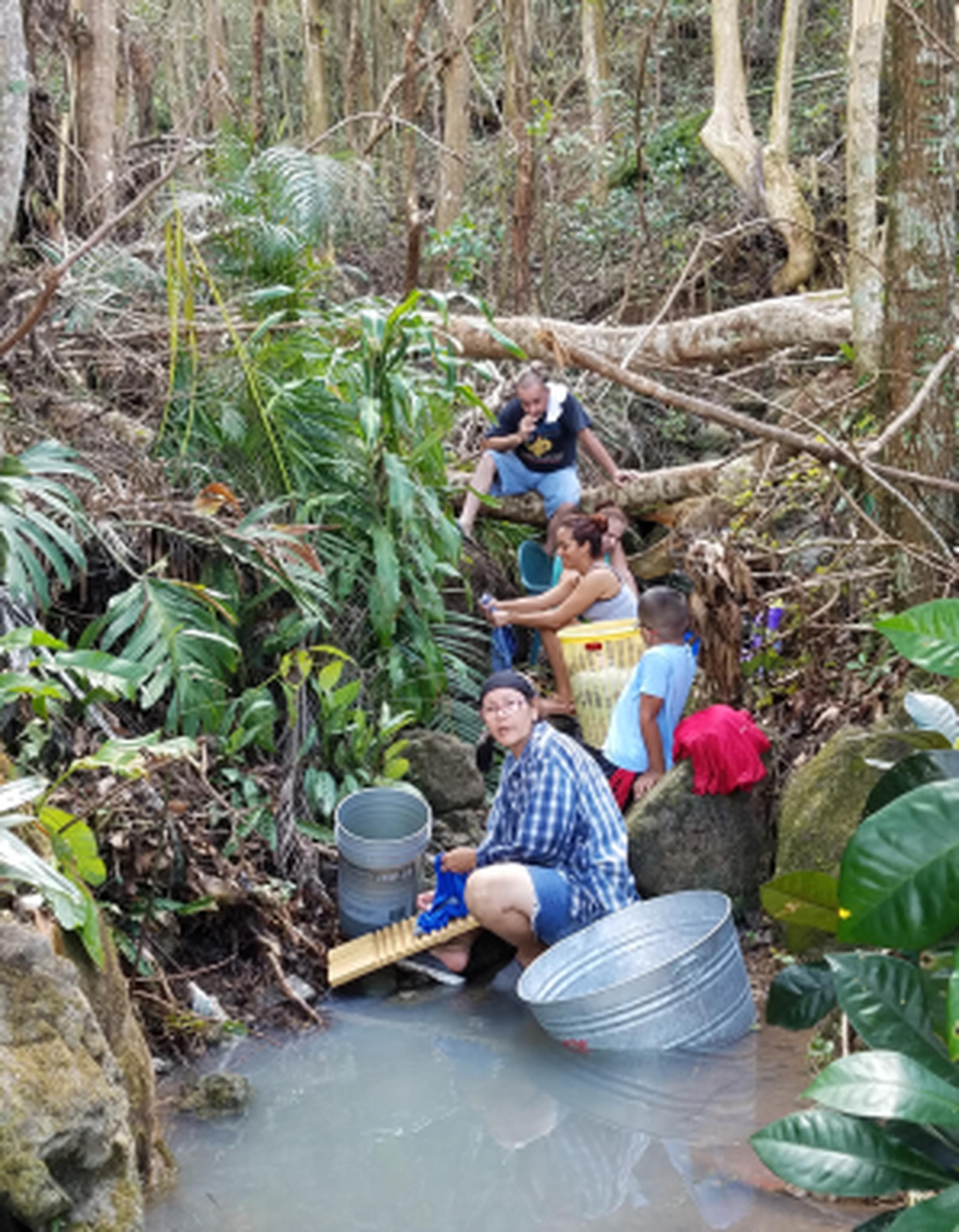 Miriam Santiago lava junto a sus vecinas en una quebrada intermitente que se llenó de agua durante el paso del huracán María. (aurora.rivera@gfrmedia.com)