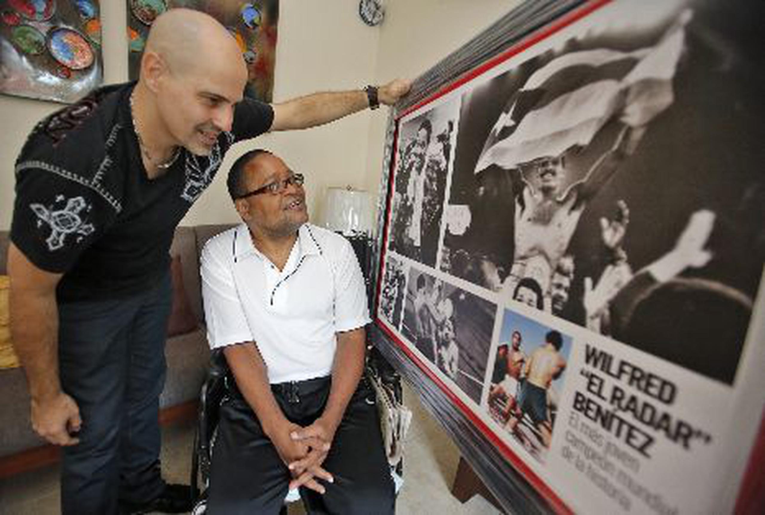   A la izquierda, el editor de deportes de Primera Hora, Noel Piñeiro Planas, le muestra a Wilfred Benítez el cuadro que se le preparó con varias imágenes de su carrera. Arriba, el ex boxeador descansa en la comodidad de la sala de su renovado hogar.