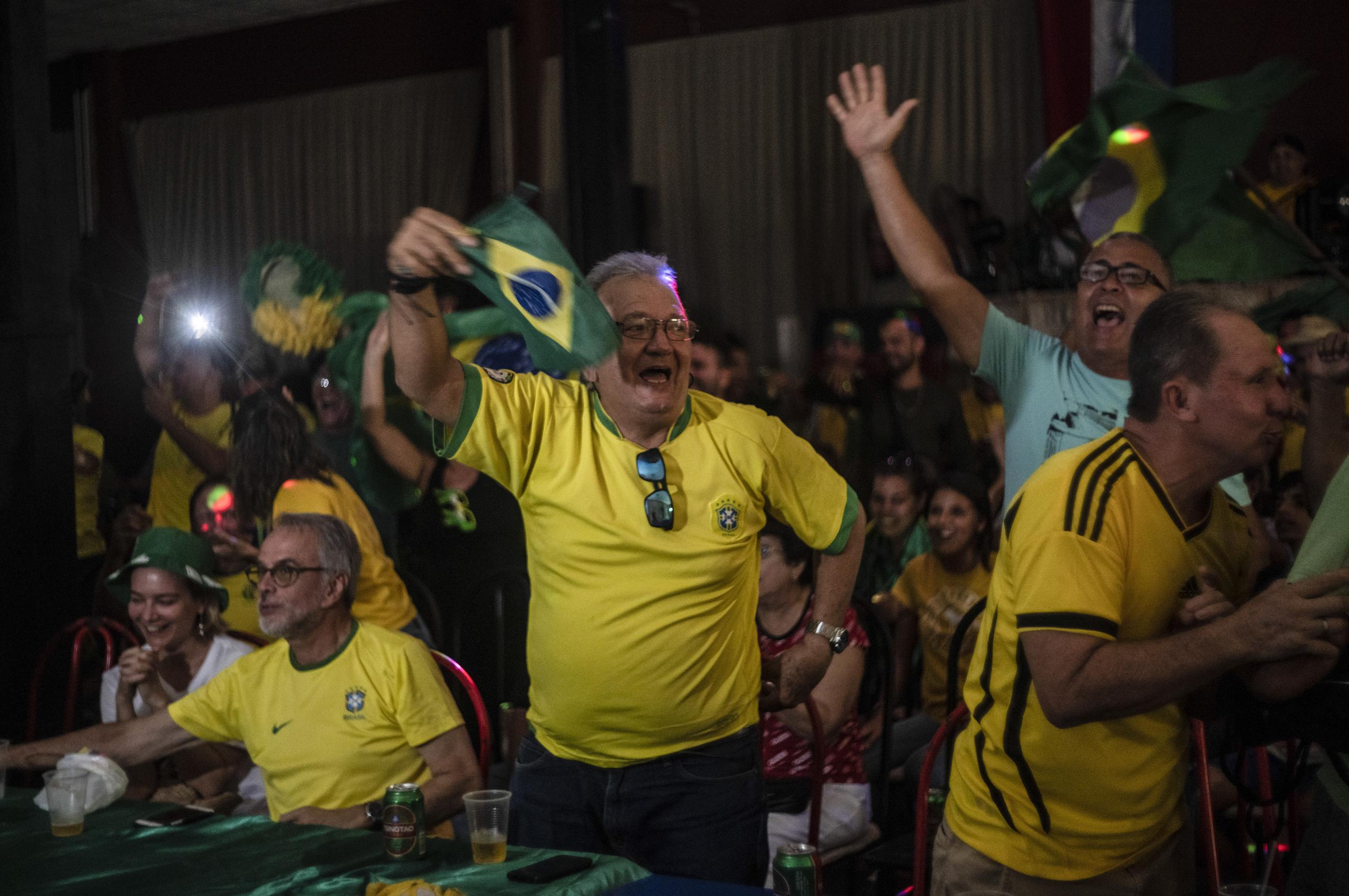 Alberto Izquierdo (centro), presidente de la asociación de aficionados de la selección brasileña en Bauta, Cuba, festeja un gol de ese equipo el lunes 28 de noviembre de 2022, en el Mundial (AP Foto/Ramón Espinosa)