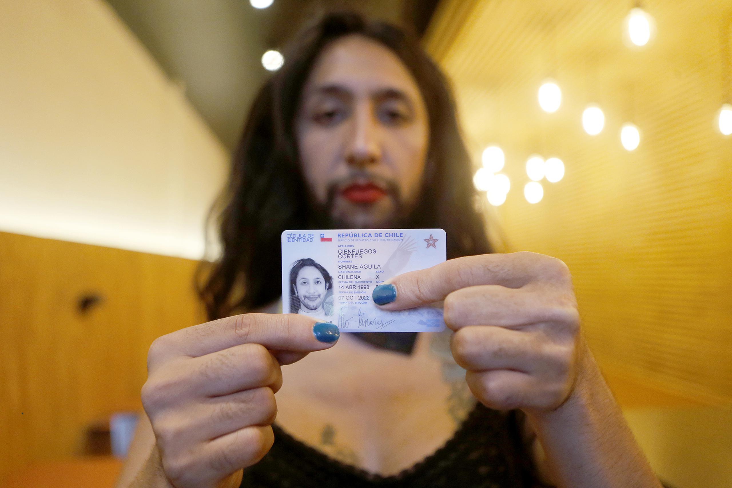 Fotografía cedida por Felipe Poga que muestra a Shane Cienfuegos mientras posa para fotografías, después de recibir su cédula de identidad que le reconoce como una persona trans no binaria, en Santiago (Chile). EFE/Felipe Poga
