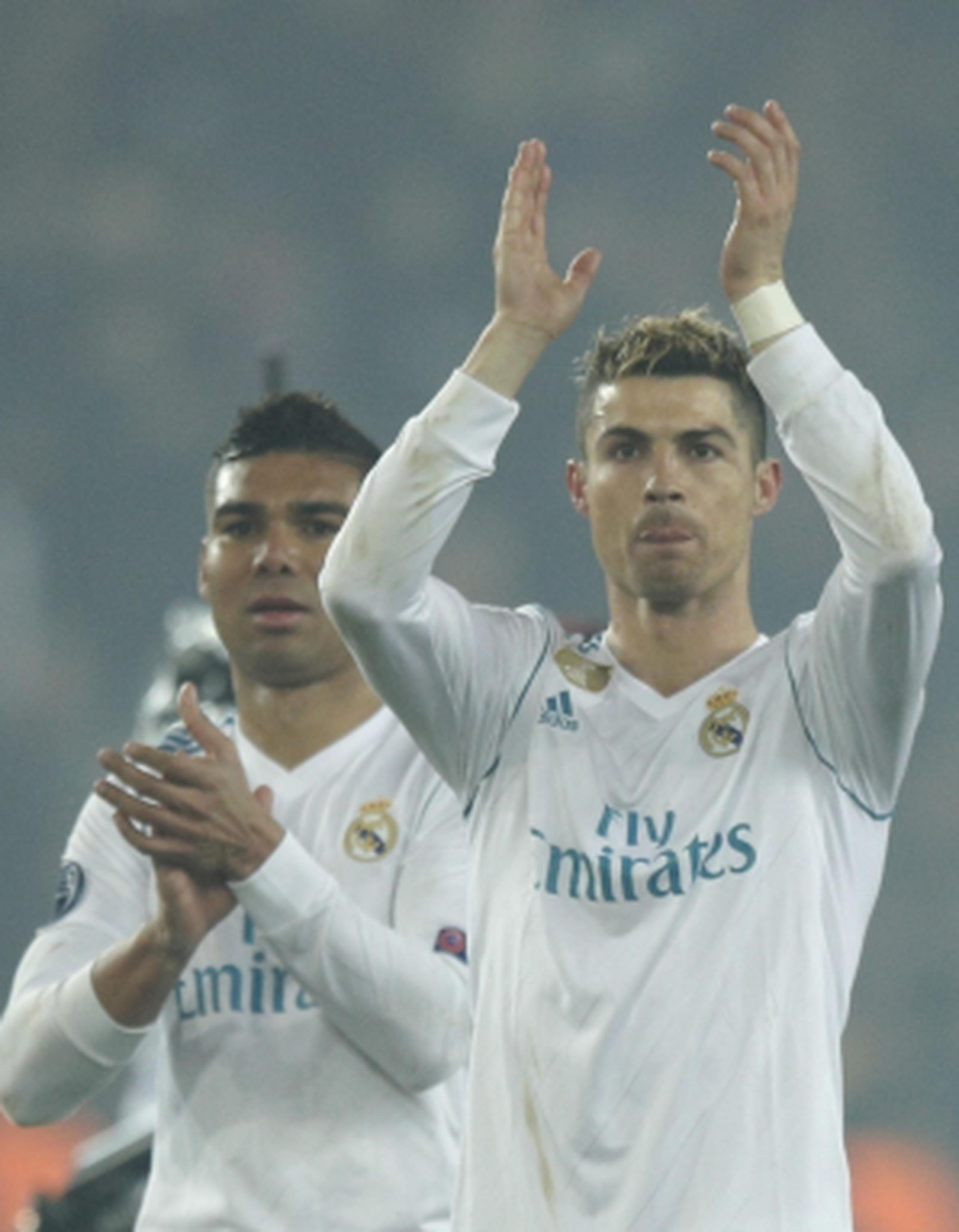 Los jugadores de Real Madrid, Cristiano Ronaldo, derecha, y Casemiro, saludan al público tras vencer 2-1 a PSG y avanzar a los cuartos de final de la Liga de Campeones el martes. (AP)