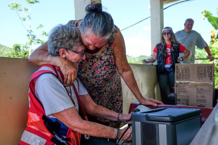 Una voluntaria de la Cruz Roja recibe un abrazo de una envejeciente tras entregarle ayuda en medio de la emergencia causada por el huracán María.