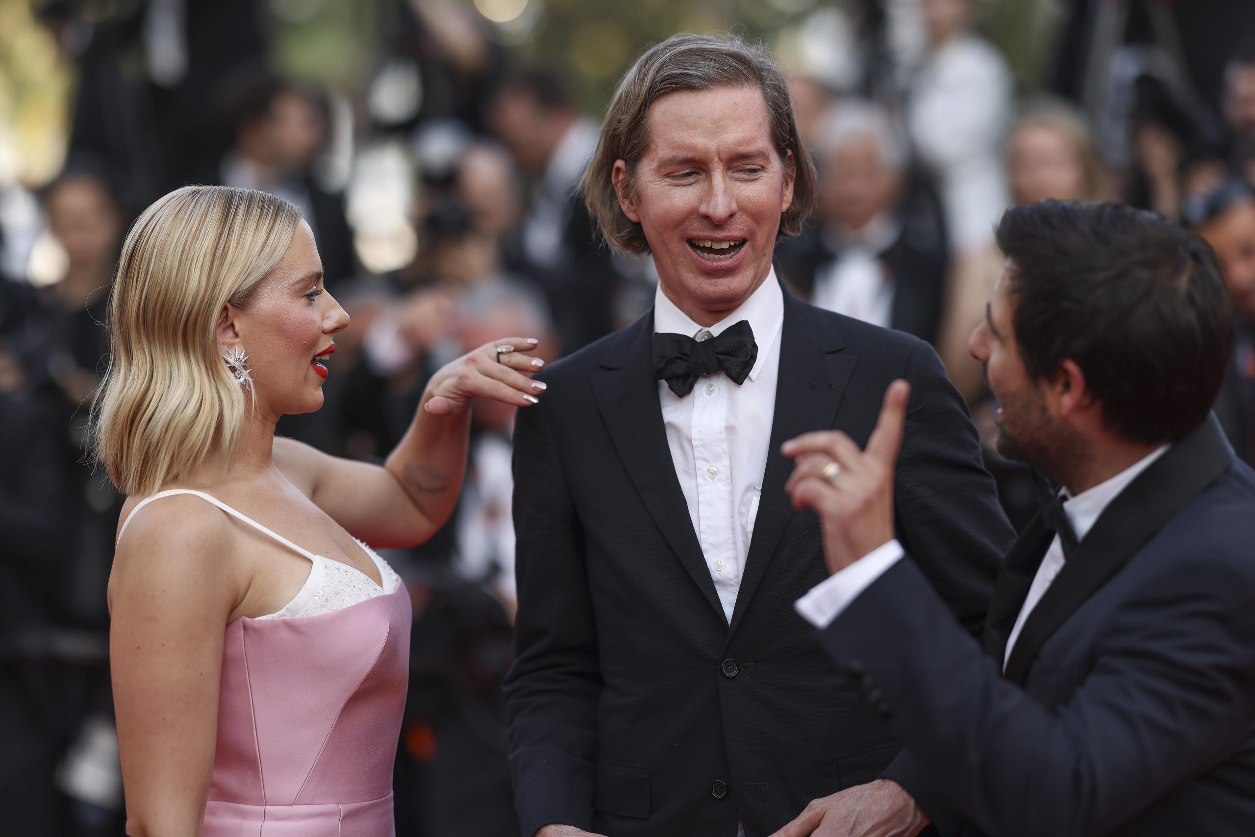 De izquierda a derecha: Scarlett Johansson, el director Wes Anderson y Jason Schwartzman posan a su llegada a al estreno de la película "Asteroid City" en la 76a edición del festival internacional de cine de Cannes, en el sur de Francia, el martes 23 de mayo de 2023. (Foto Vianney Le Caer/Invision/AP)