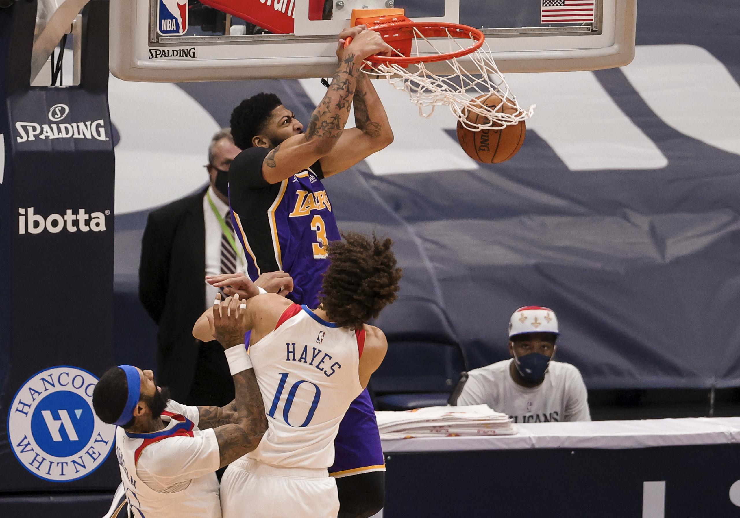 Anthony Davis, de los Lakers, donquea fuertemente durante el encuentro del domingo ante los Pelicans de Nueva Orleans.