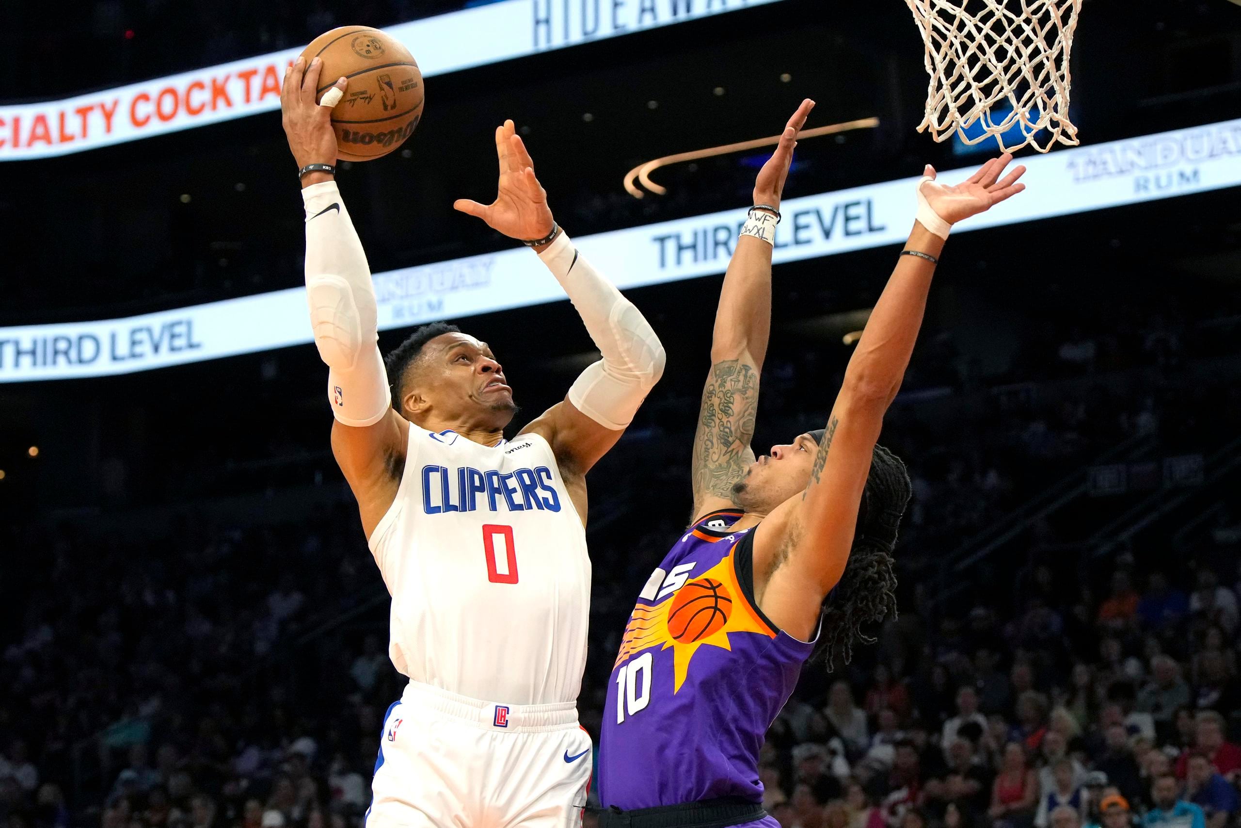Russell Westbrook (0) de los Clippers de Los Ángeles intenta anotar ante Damion Lee de los Suns de Phoenix, el domingo 9 de abril de 2023. (AP Foto/Rick Scuteri)