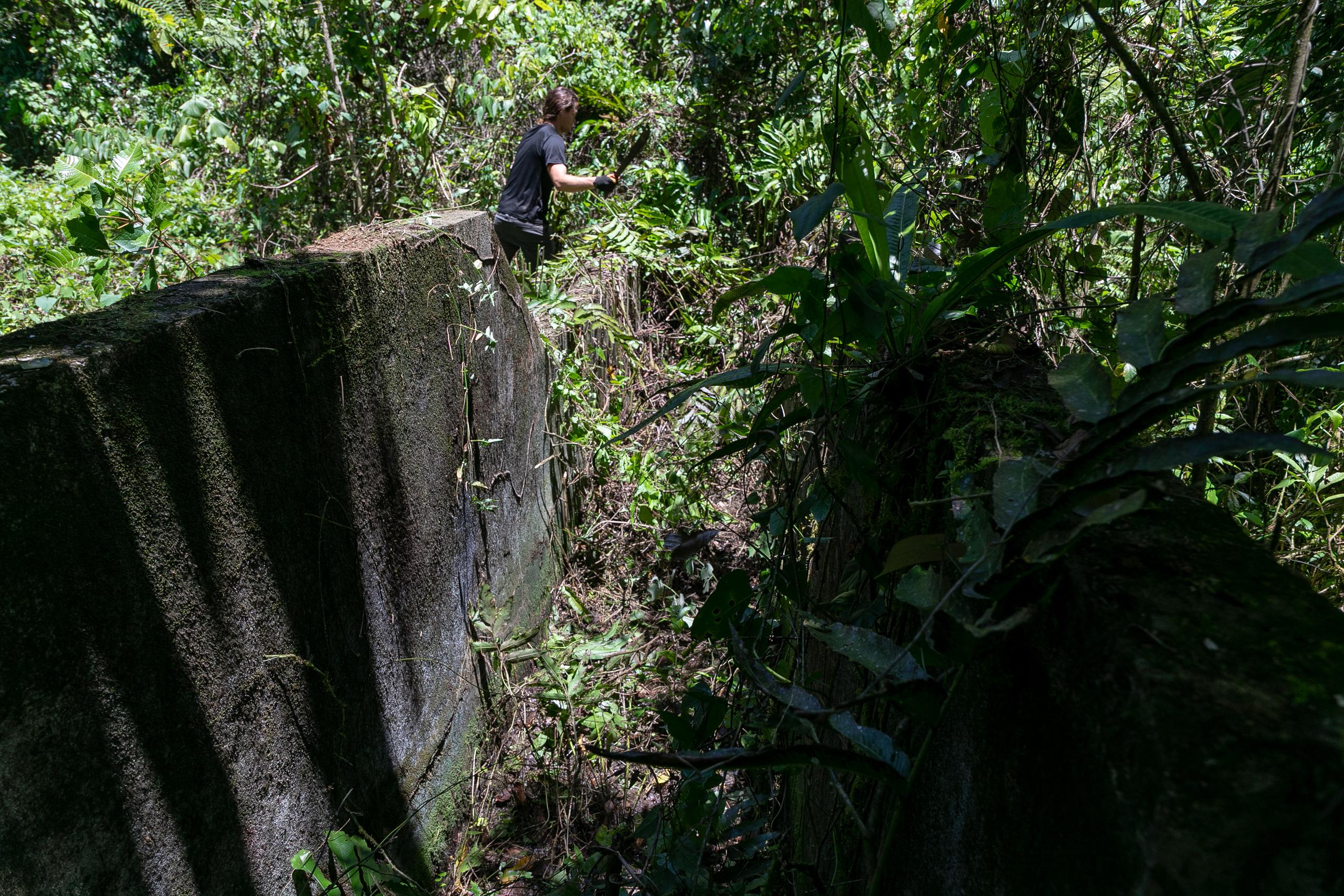 Recorrido por áreas de bosque en el barrio Santa Rosa, de Utuado, donde hubo una comunidad. En la foto, Carlos Alfredo Pérez Haeussler muestra una antigua estructura que se utilizaba para bañar y desinfectar animales.