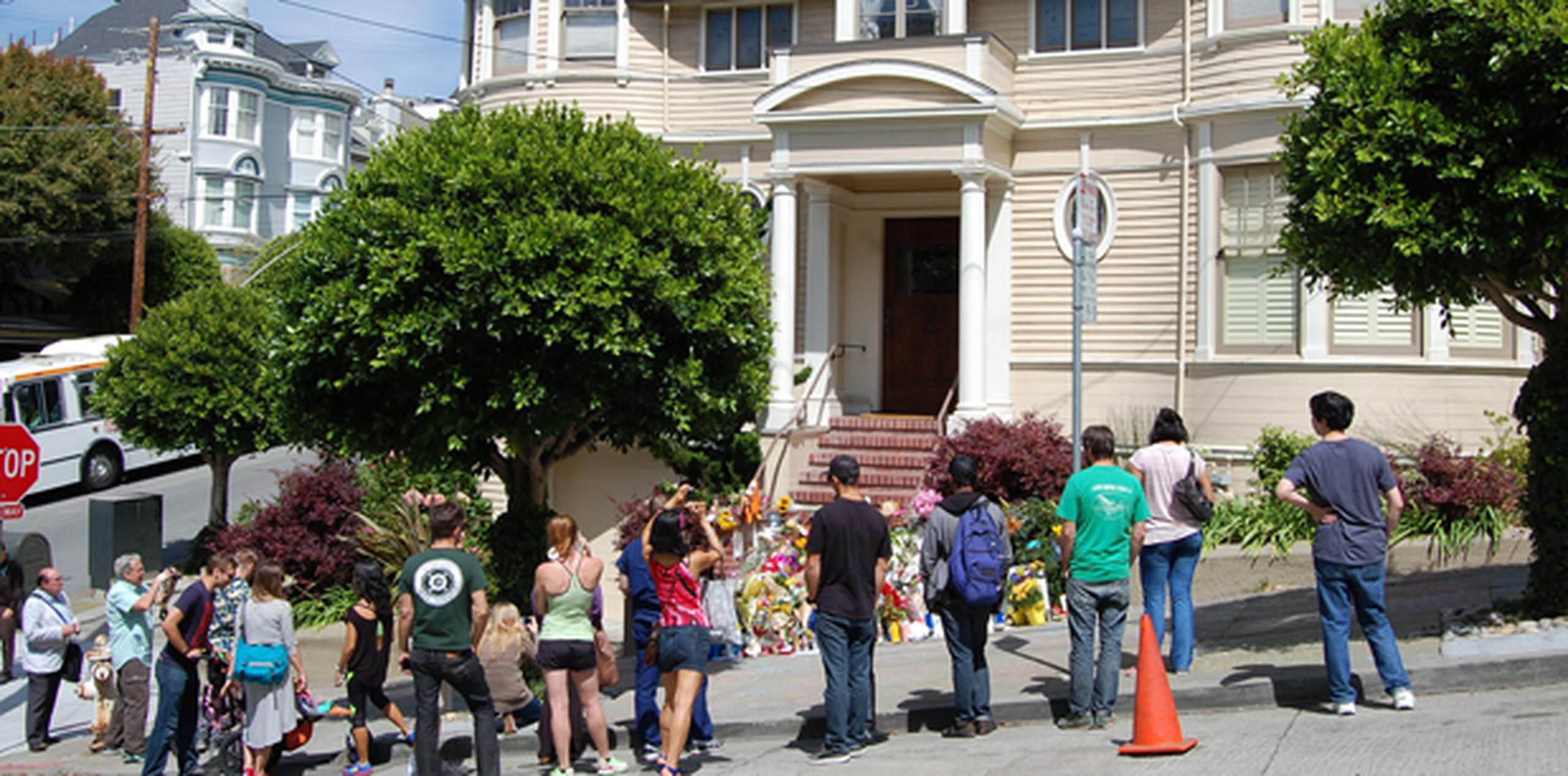 Ramos de flores de todos los colores, velas, dedicatorias, fotografías y peluches se amontonan sobre las escaleras de acceso a la casa de estilo victoriano de la calle Steiner de San Francisco. (EFE)