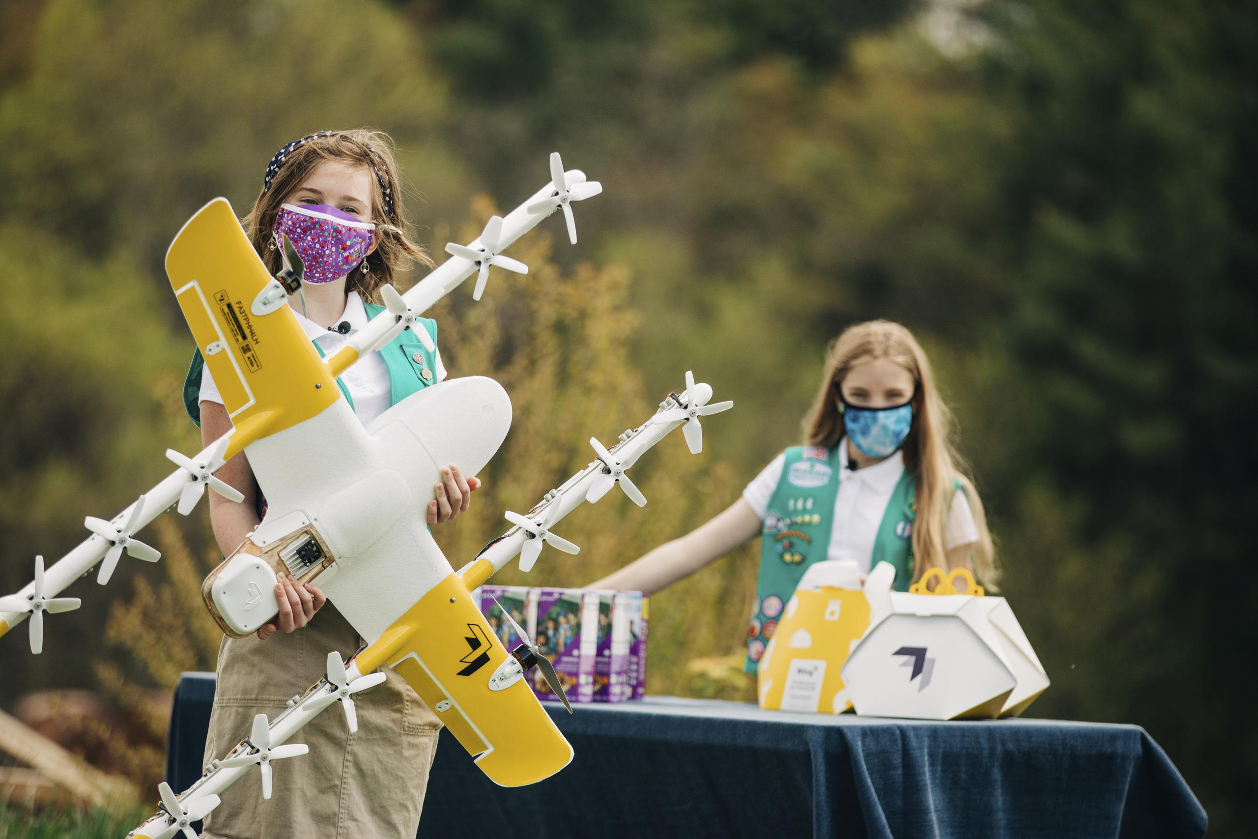 Las Girl Scouts Alice Goerlich y Gracie Walker posando con un dron para entregar las galletas que venden en Christiansburg, Virginia.