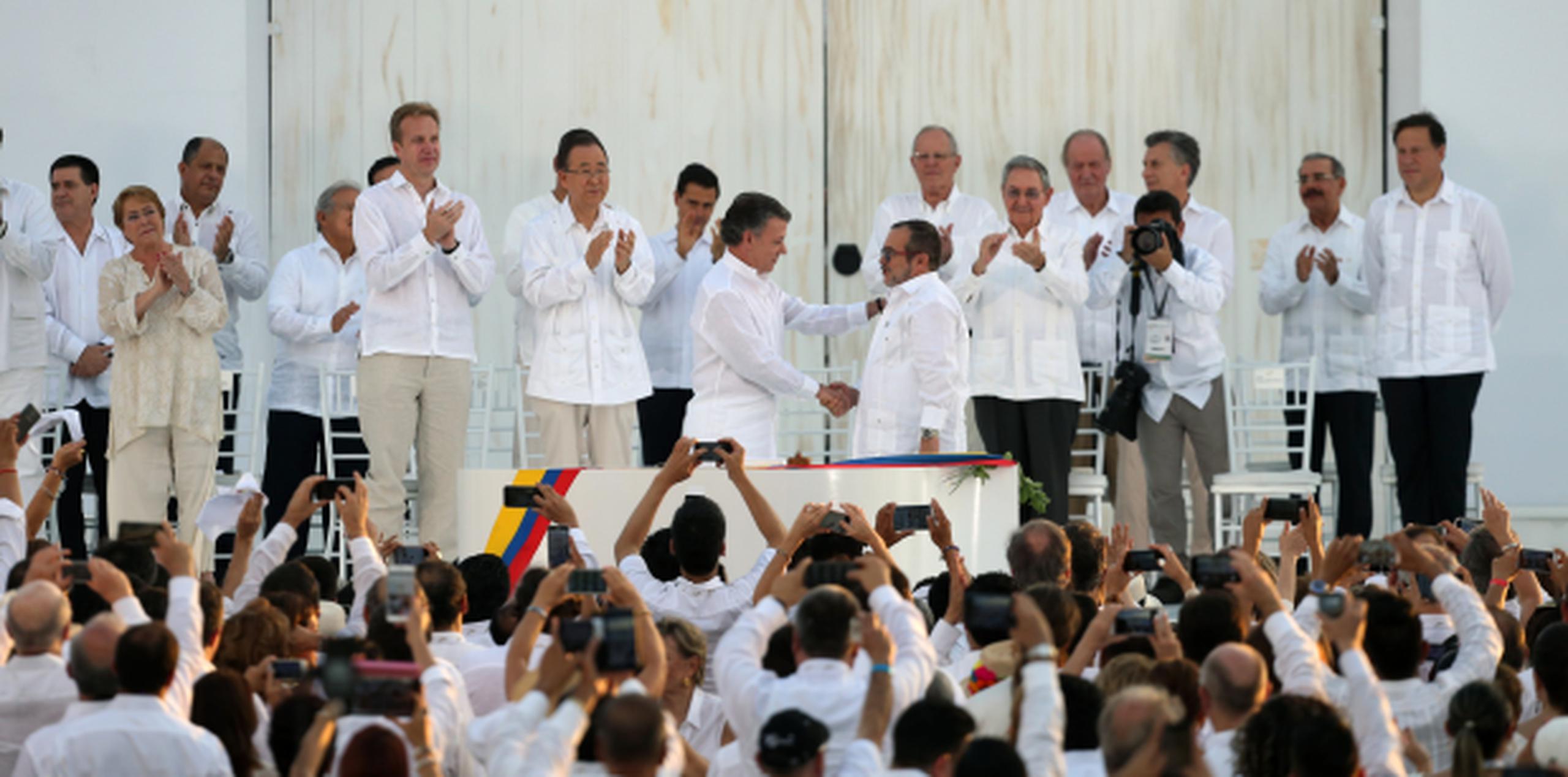 El presidente de Colombia, Juan Manuel Santos y el máximo comandante de las FARC, Rodrigo Londono, se dan la mano durante el acuerdo de paz. (AP/Fernando Vergara)