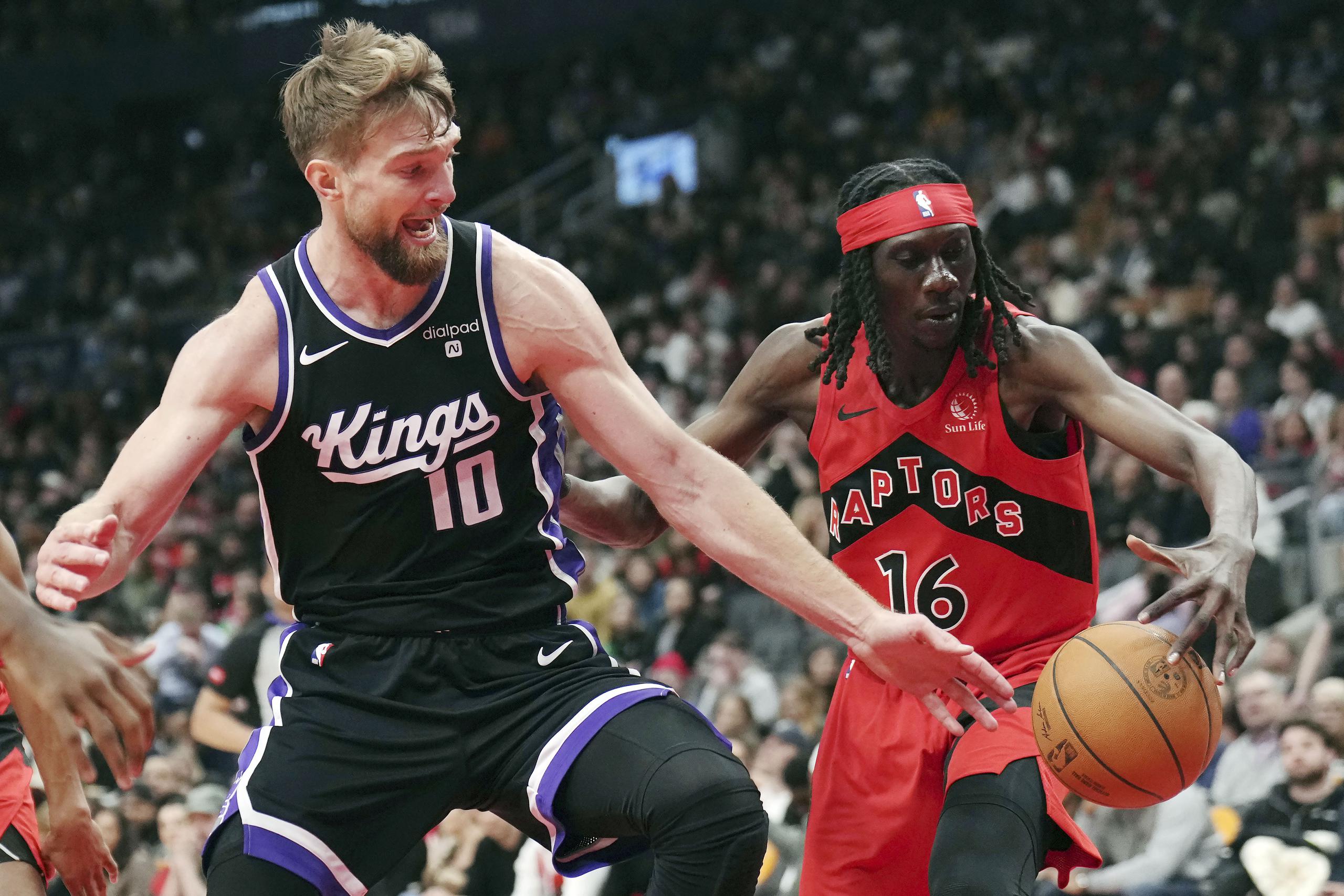 El ala-pívot de los Kings de Sacramento Domantas Sabonis (10) y el alero de los Raptors de Toronto Mouhamadou Gueye (16) disputan el balón durante la segunda mitad del juego de baloncesto de la NBA.