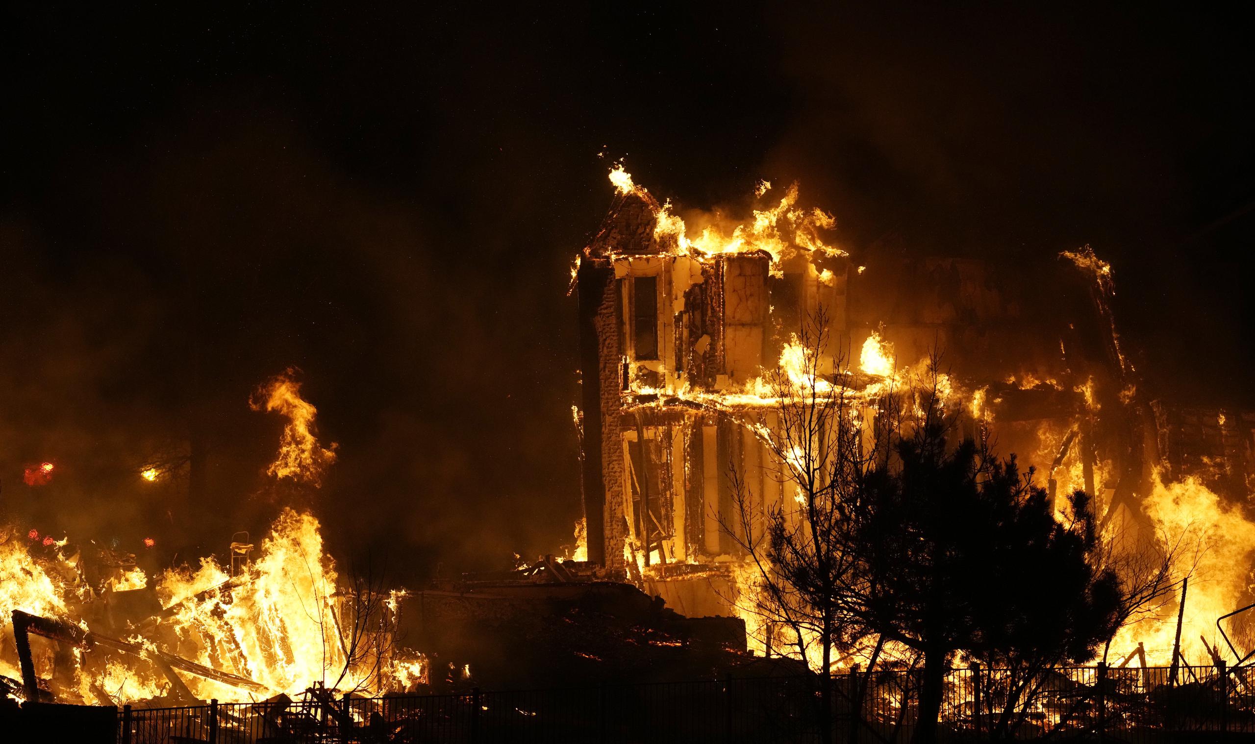 Dos casas arden a causa de un incendio forestal cerca de Rock Creek Village, en Colorado, el 30 de diciembre de 2021.
