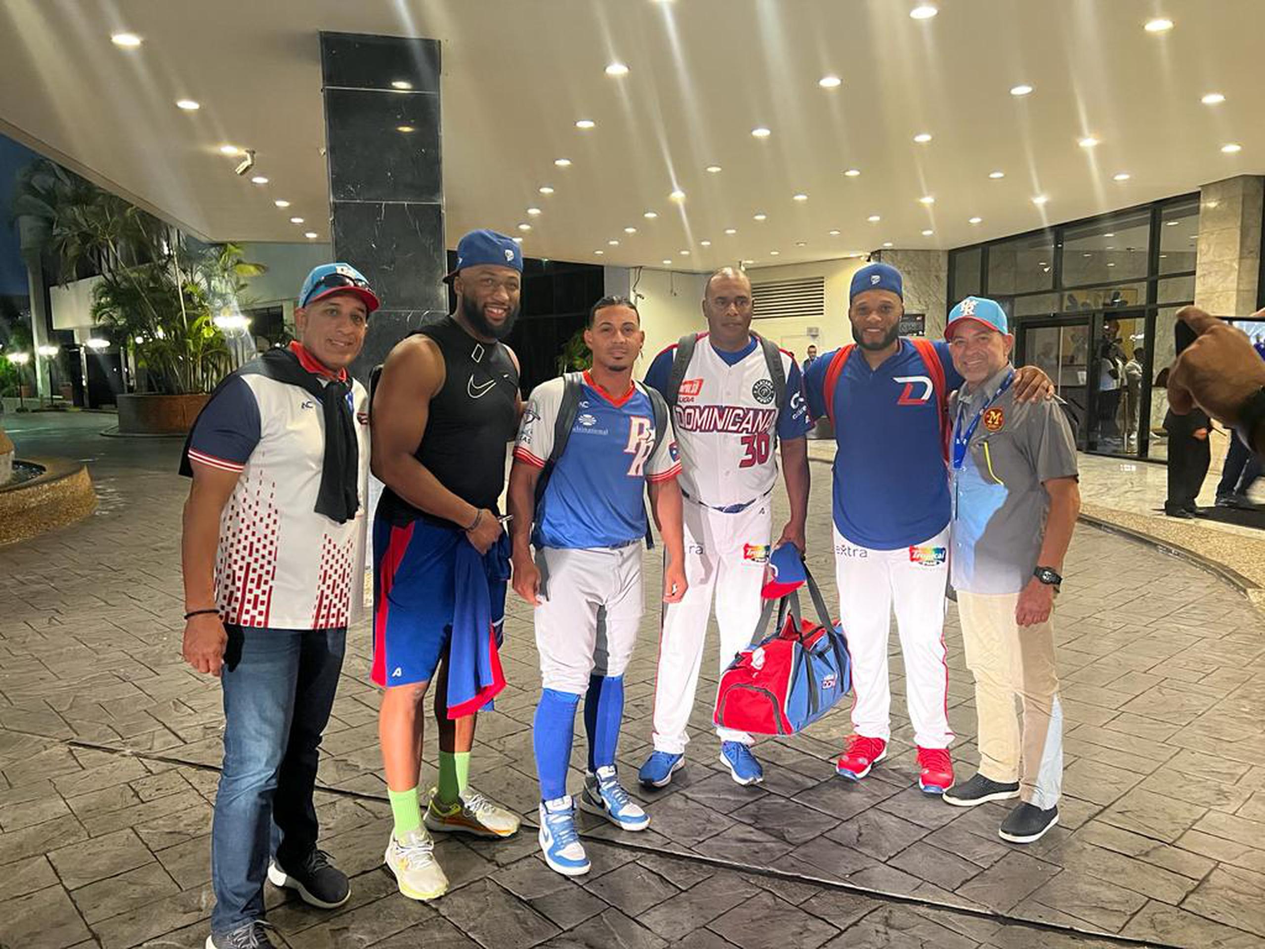 Tanto Luis Leroy Cruz, tercero desde la izquierda, como José Offerman, a su lado derecho, participaron en la conversación con otros integrantes del equipo dominicano a la llegada al hotel que comparten.