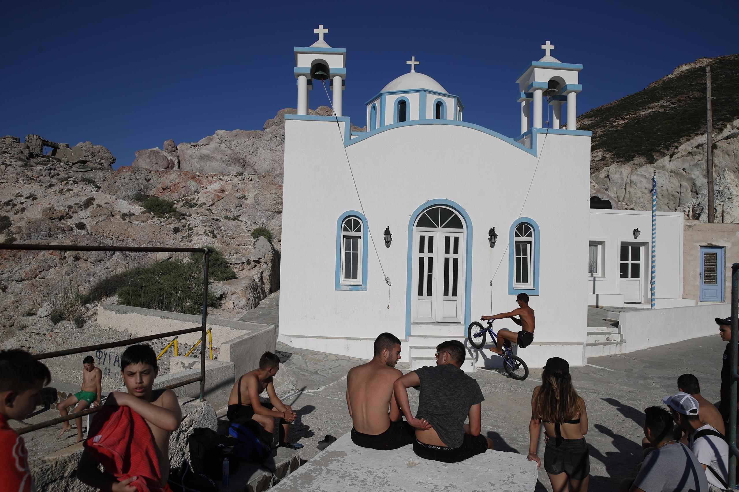 Niños y jóvenes reunidos ante una iglesia ortodoxa griega en la isla de Milos, en el mar Egeo