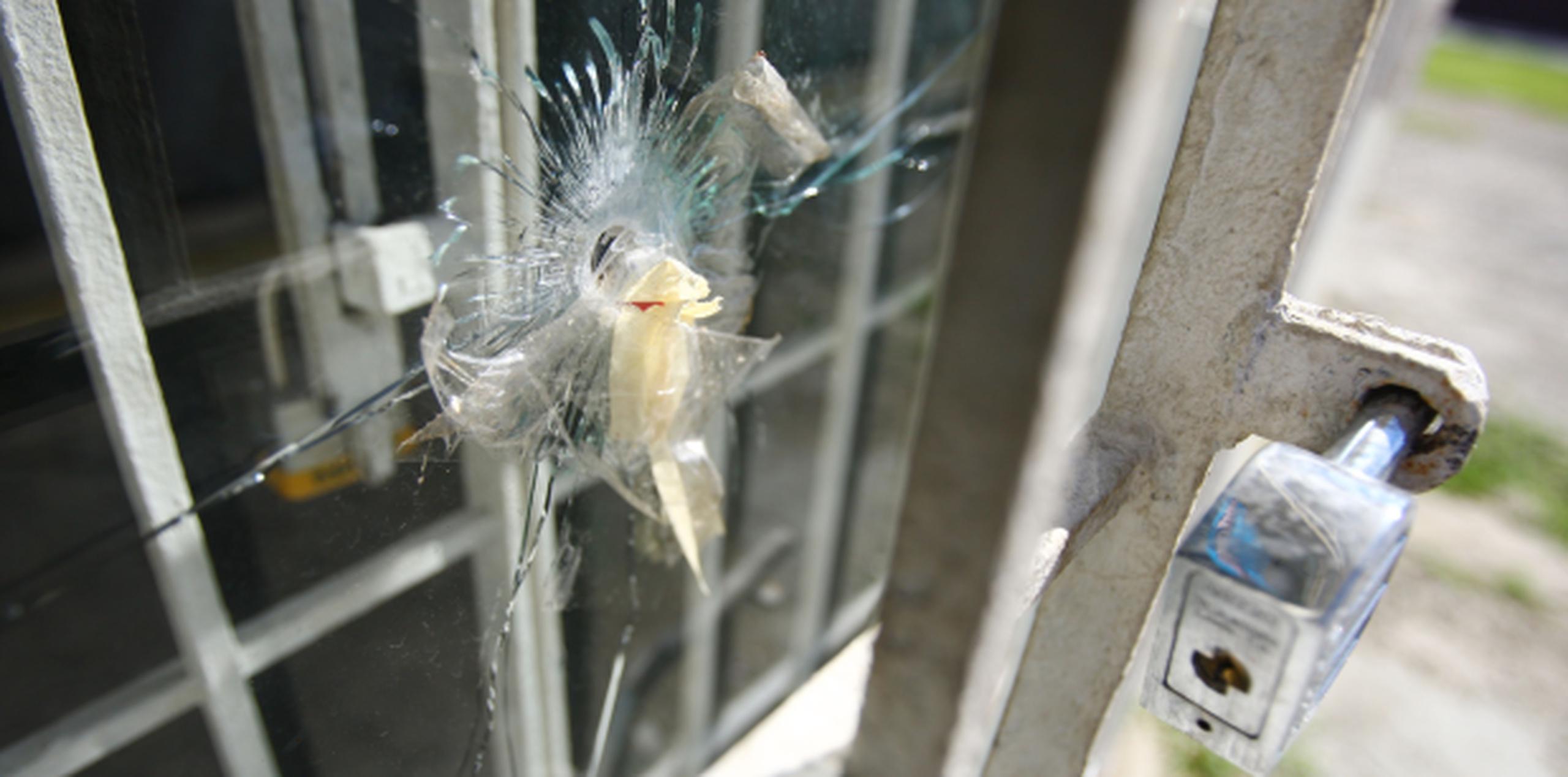 Una bala en uno de los cristales del negocio La Tómbola permanecee como recuerdo de la tragedia ocurrida en octubre de 2009. (Archivo)