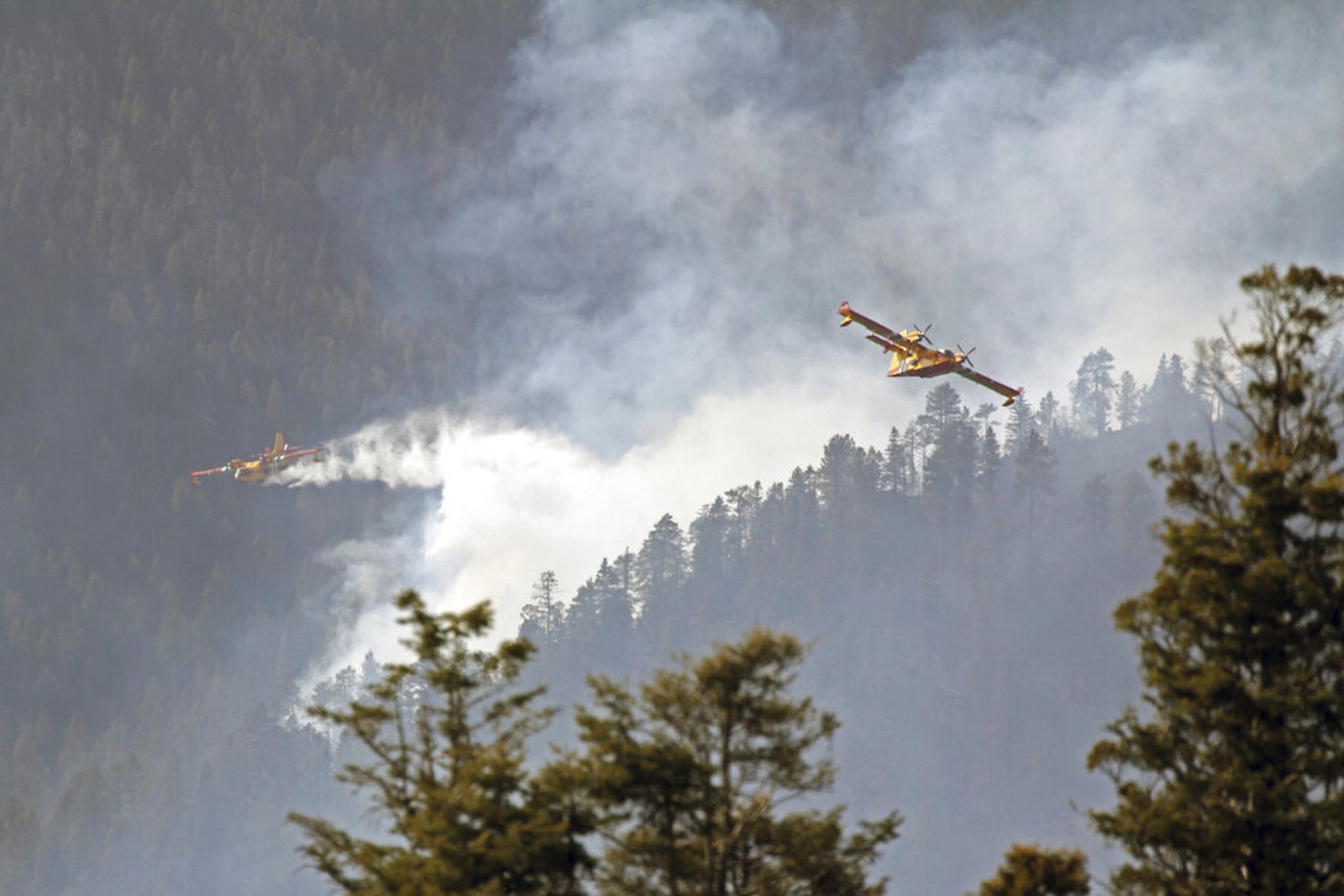 Fotografía del Servicio Forestal de Estados Unidos de aviones conocidos como "super scoopers" combatiendo incendios en el Bosque Nacional Santa Fe en Nuevo México, el 26 de abril de 2022.