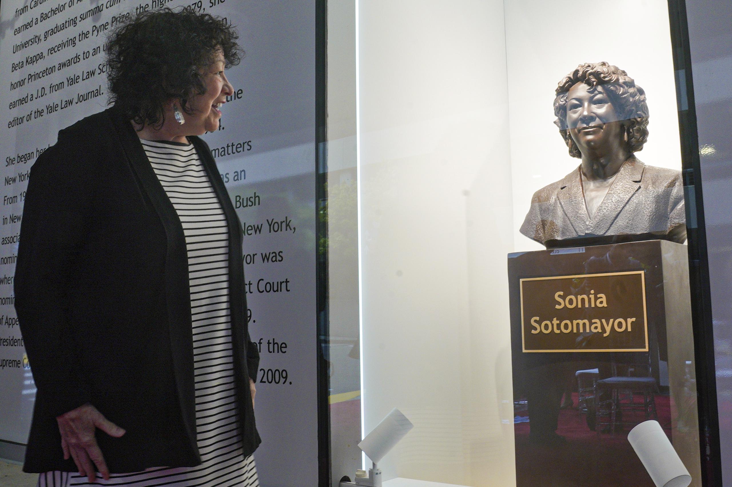 La jueza de la Corte Suprema Sonia Sotomayor mira un busto e bronce en su honor inaugurado el 8 de septiembre del 2022 en el distrito del Bronx, Nueva York.  (AP PFoto/Bebeto Matthews, Pool)