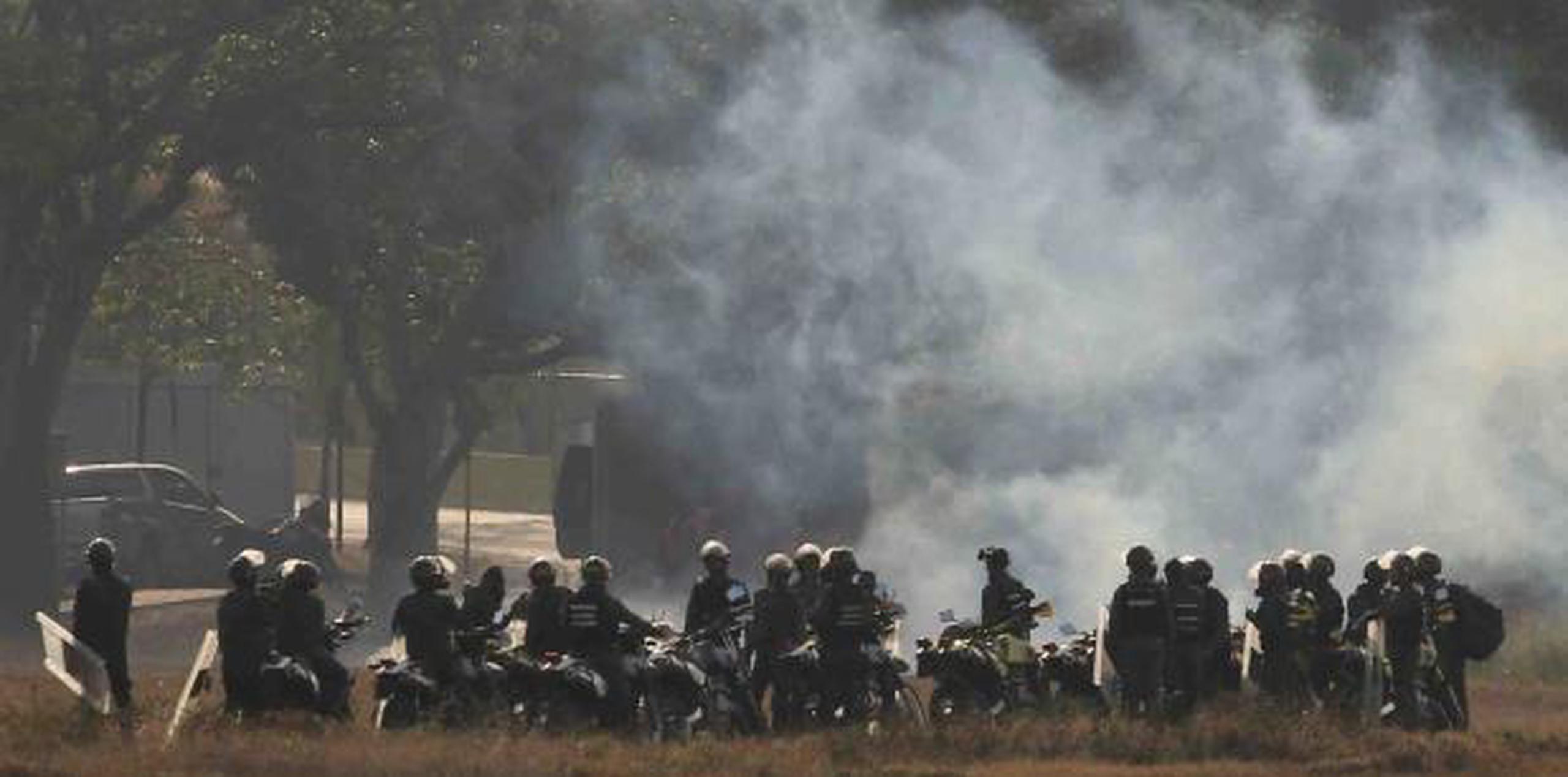 Soldados leales a Maduro disparan gases a la base donde está Guaidó, conocida como La Carlota. (AP)
