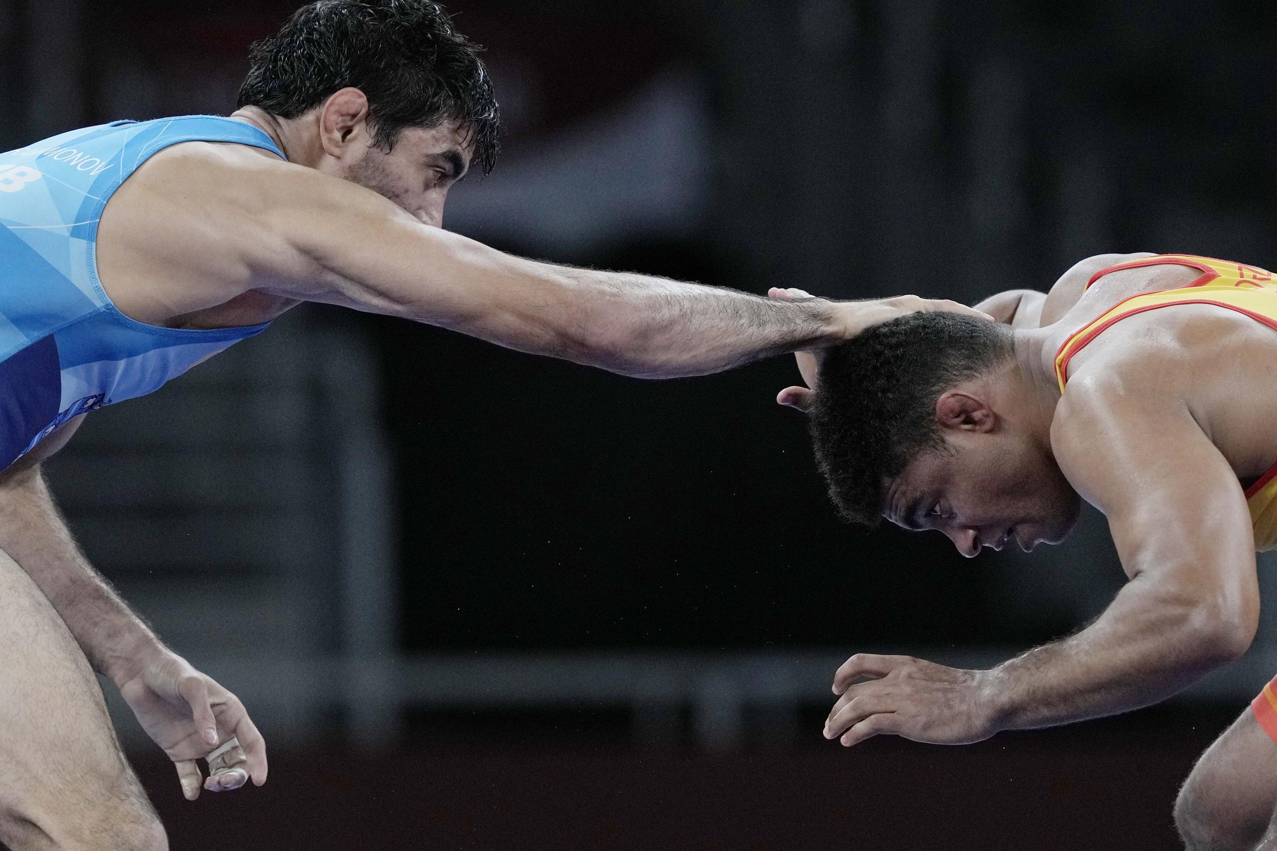 Bekzod Abdurakhmonov, a la izquierda, intenta agarrar a Franklin Gómez durante su combate del miércoles en los 74 kilogramos de la lucha olímpica.