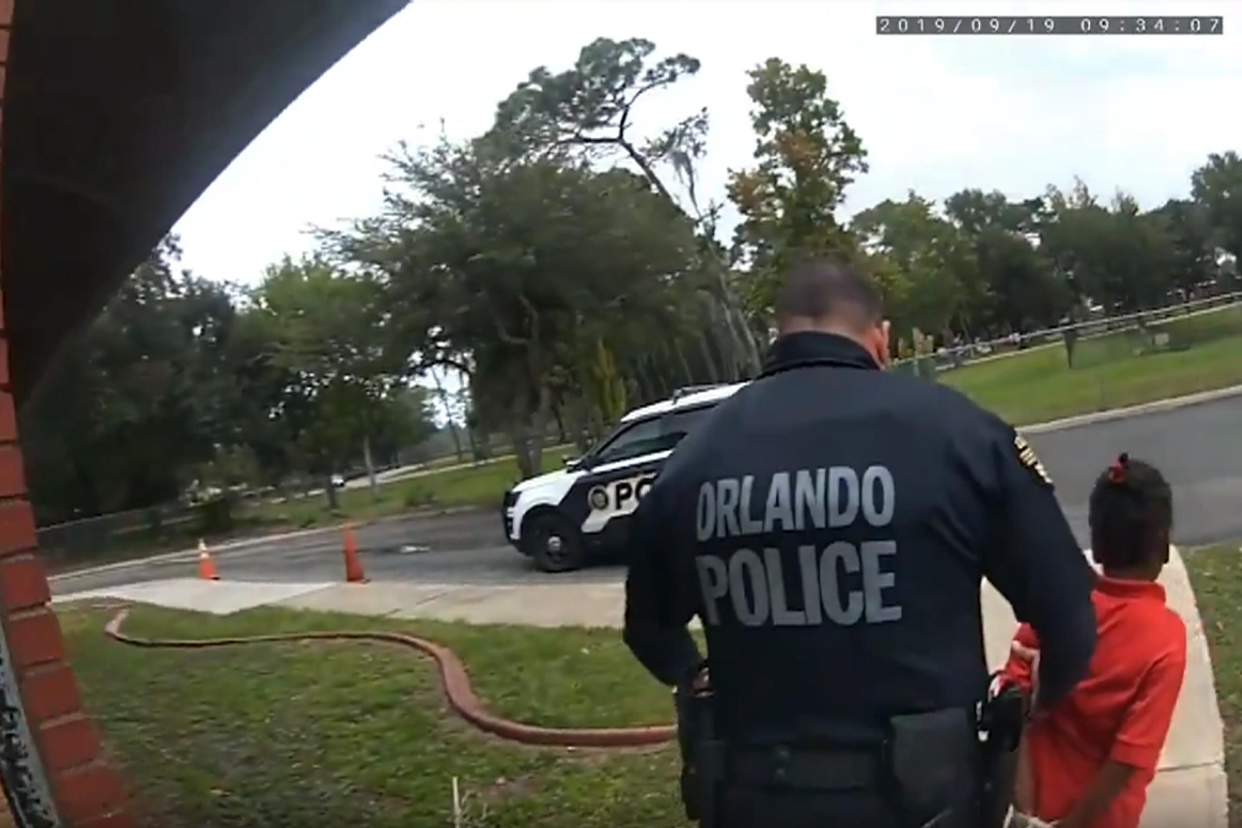 El agente Dennis Turner saca esposada a Kaia Rolle, de 6 años, de su escuela en Orlando. (Orlando Police Department/Orlando Sentinel via AP)