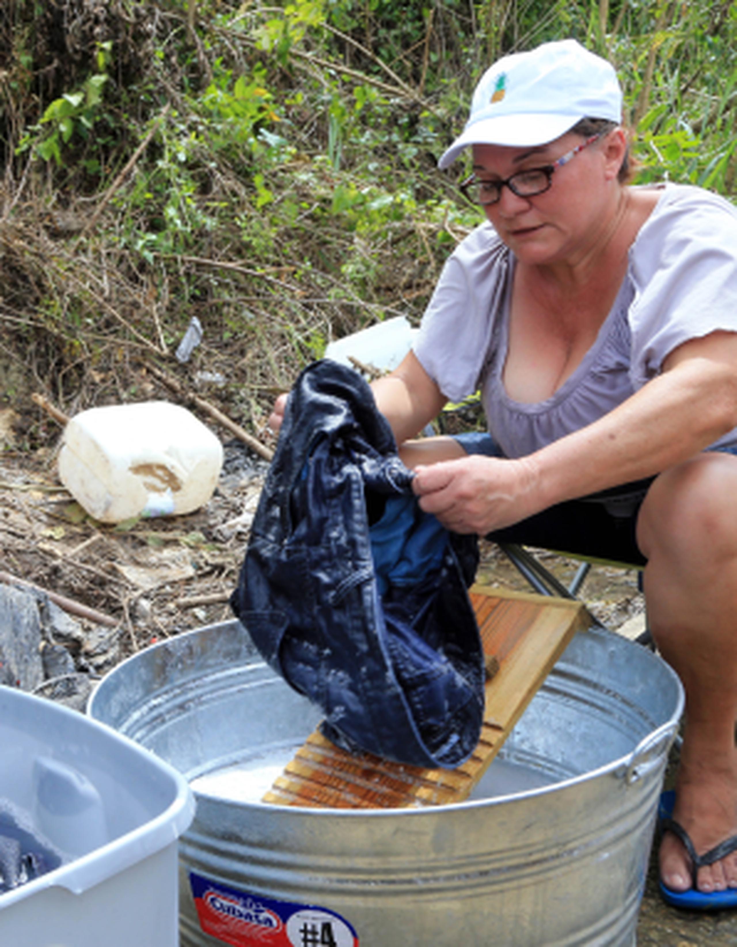 Carmen Bonilla lava la ropa a mano en una charca cerca de su casa.  (david.villafane@gfrmedia.com)
