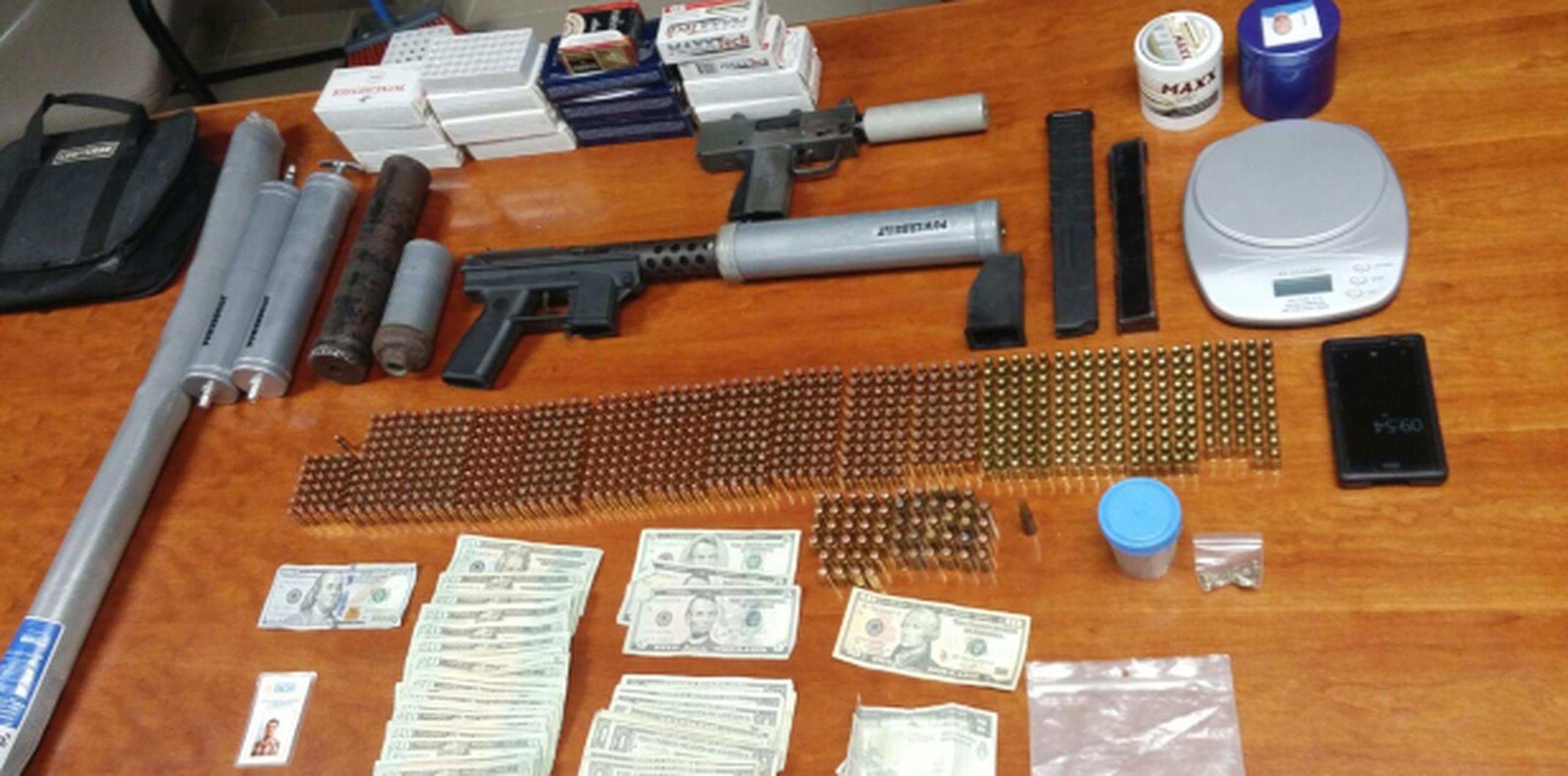 Parte de las armas, municiones, drogas y dinero ocupado en Camuy. (Suministrada)