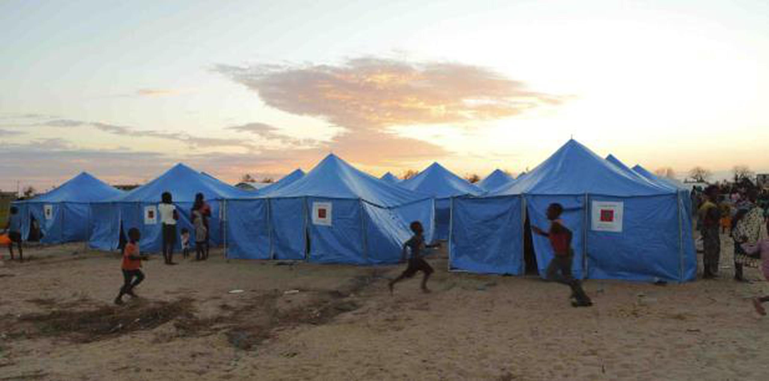 Mujeres y los niños son vistos fuera de un campamento de desplazados en Beira, Mozambique. (AP / Tsvangirayi Mukwazhi)