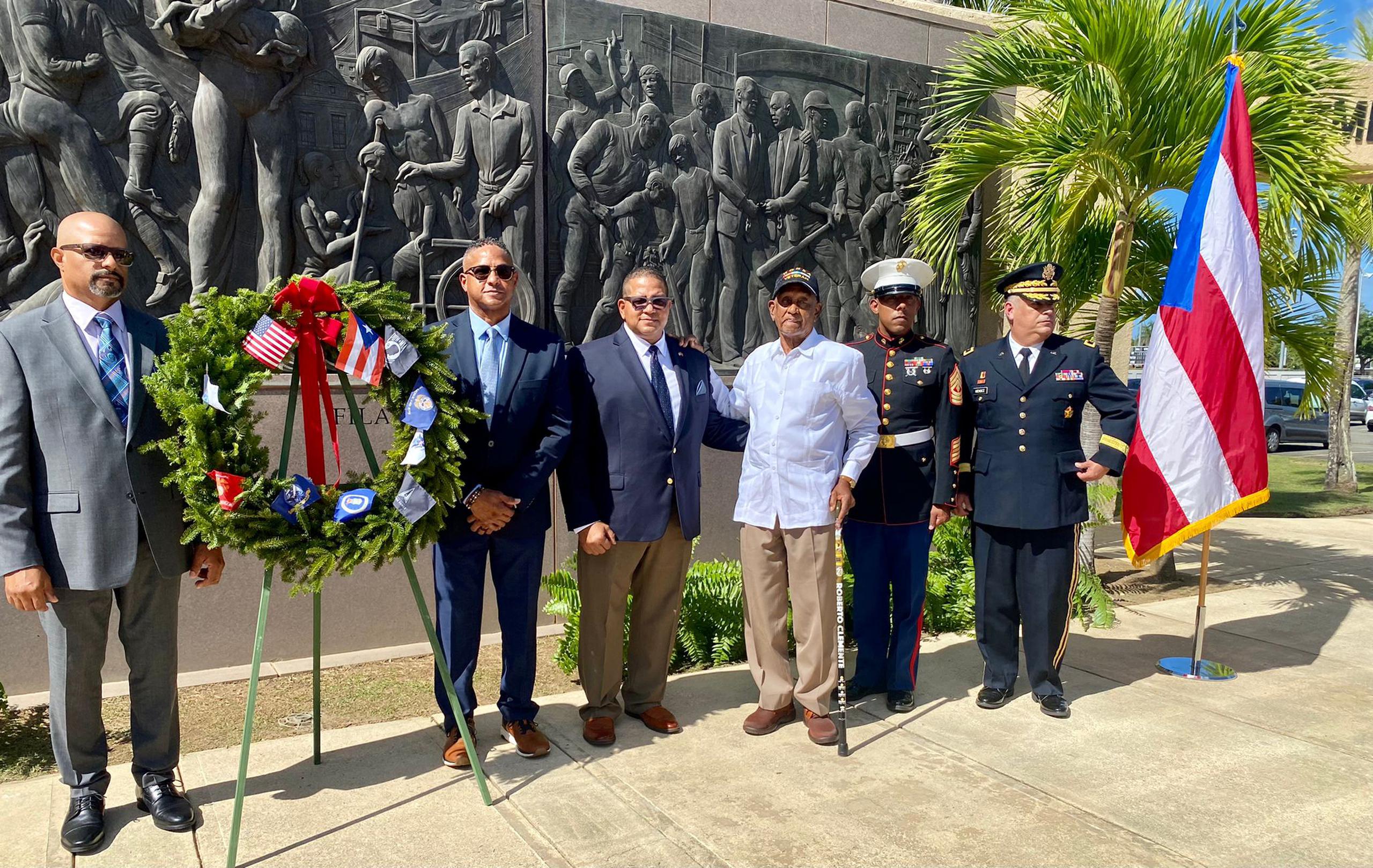 La familia Clemente posa frente al cenotafio del Astro Boricua durante la ceremonia en que el servicio militar de Estados Unidos rindió un homanaje este lunes a Clemente.