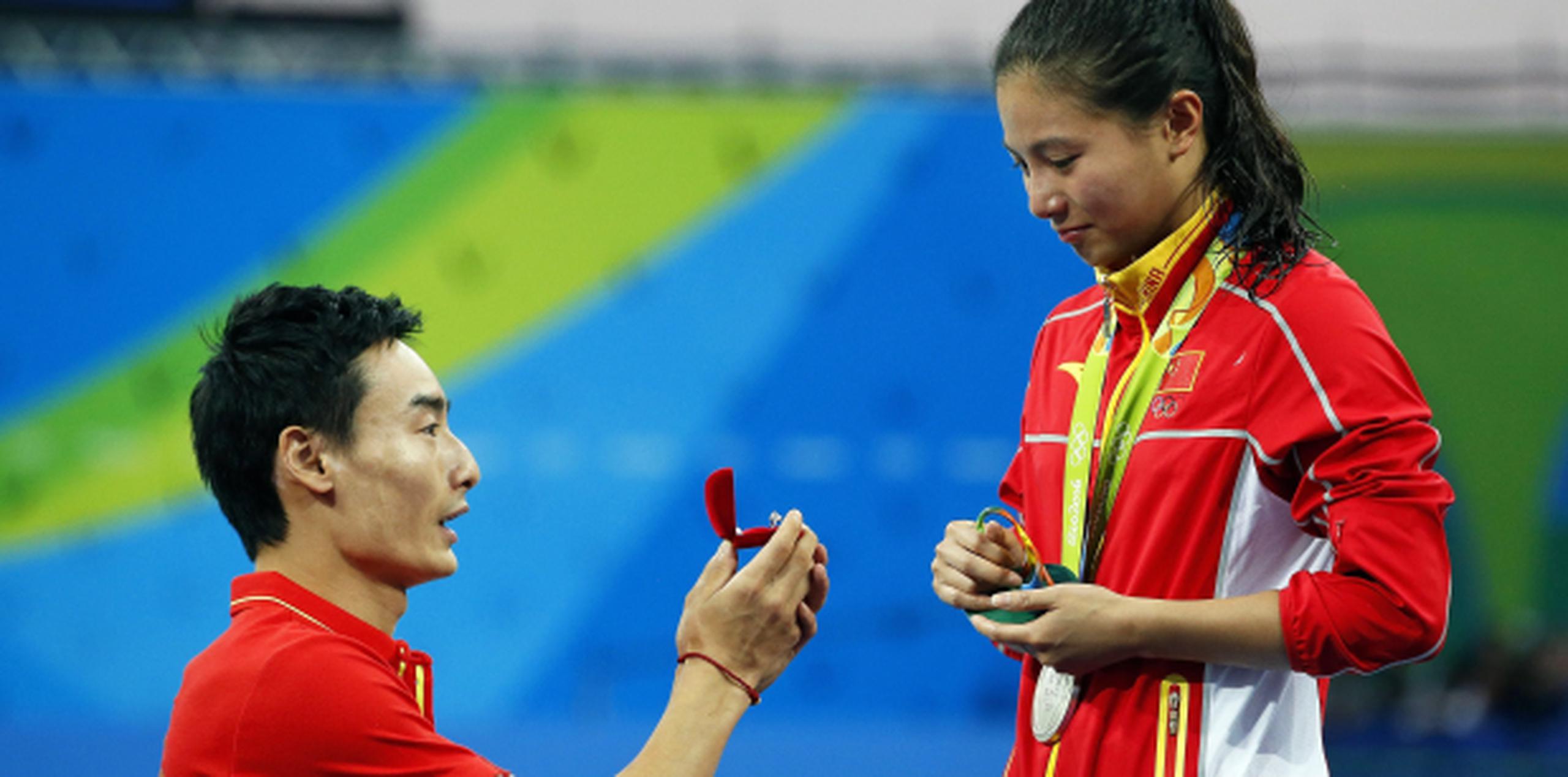 El clavadista Ki Qin se arrodilla para pedirle matrimonio a su novia, la clavadista He Zi, luego que ella recibiera la medalla de plata del evento de trampolín de tres metros. (EFE/EPA/PATRICK B. KRAEMER)
