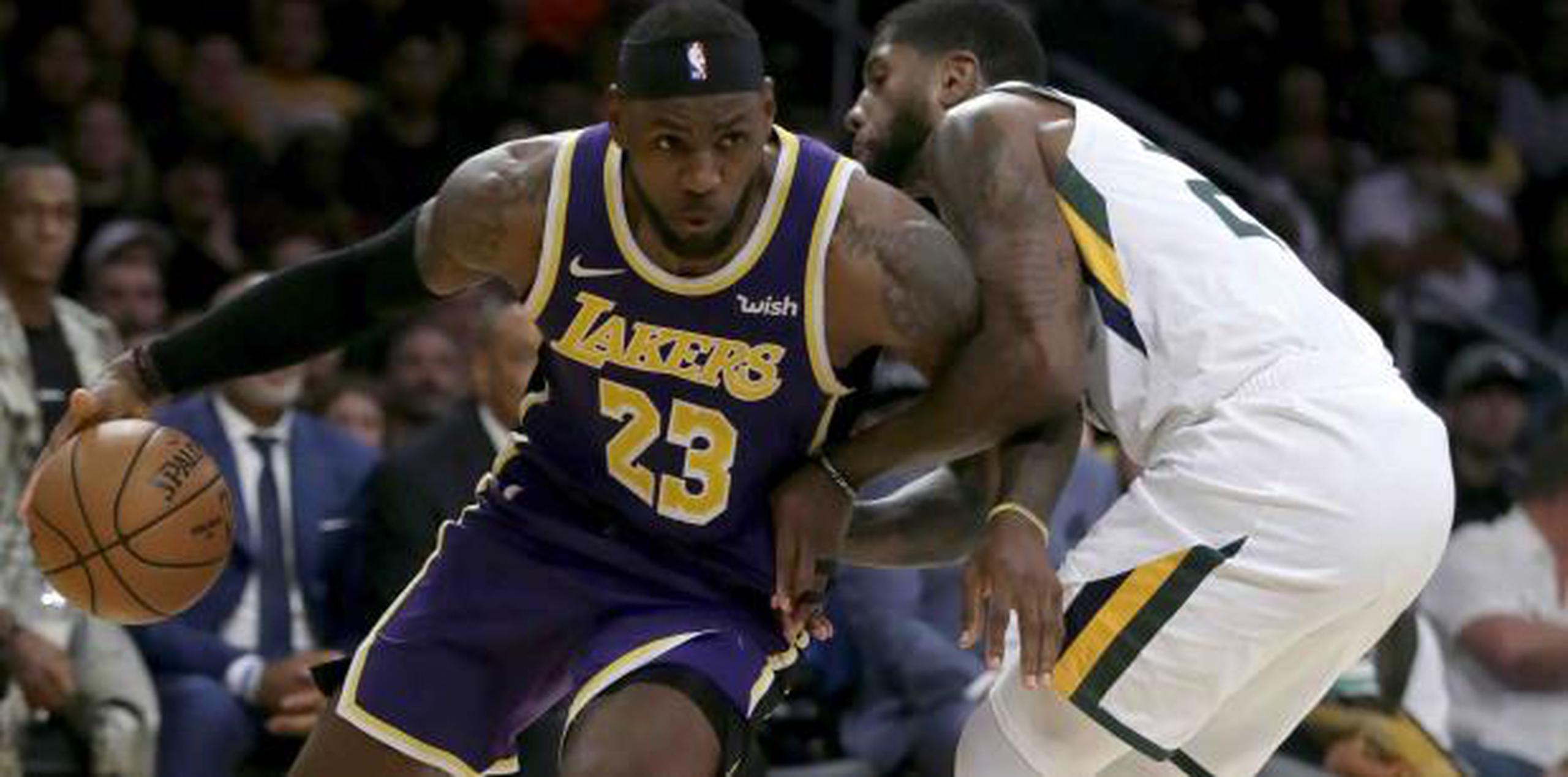LeBron James penetra ante la defensa de Royce O'Neale, del Jazz. (AP)