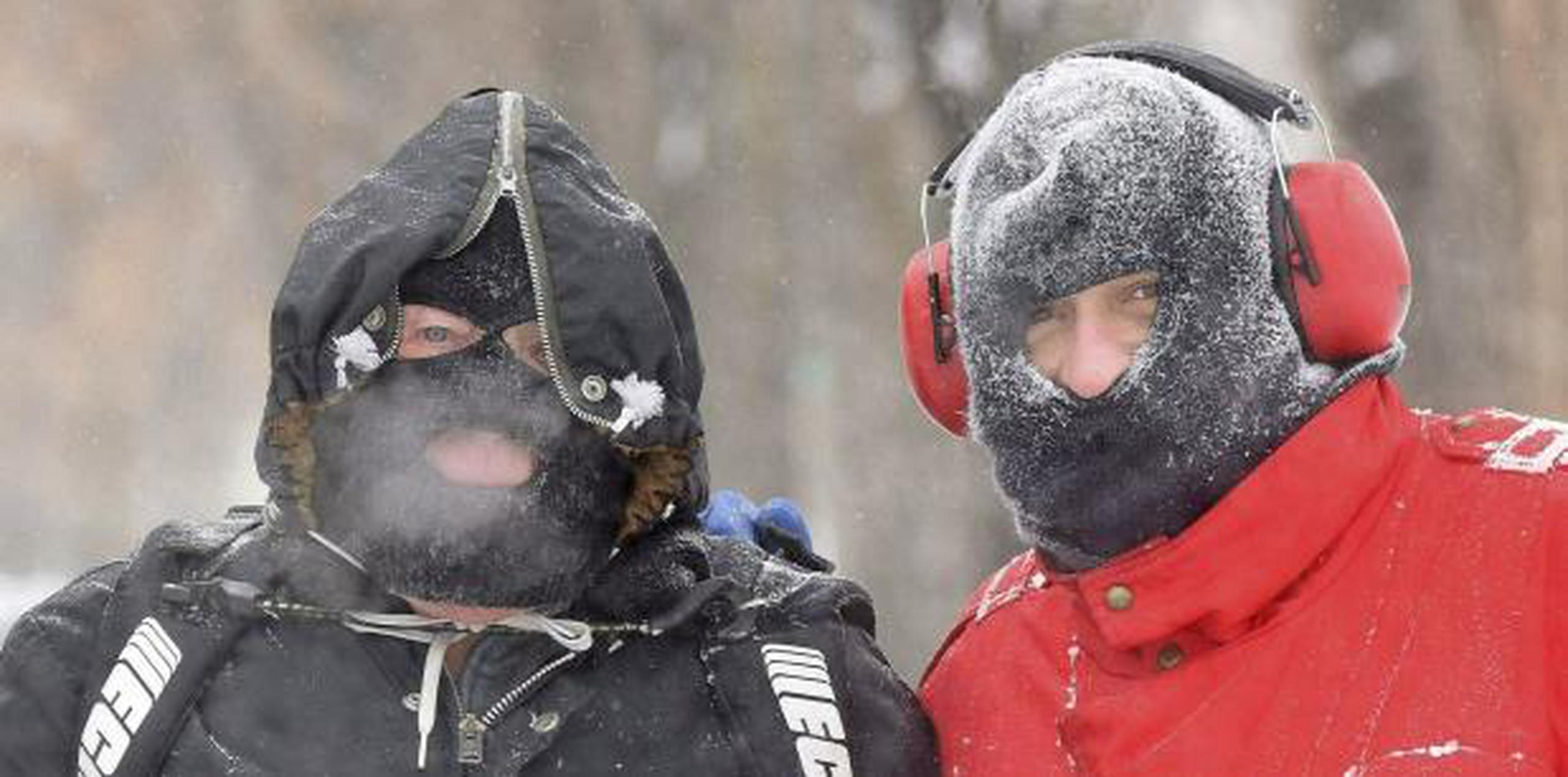 John y Johnny Nagel, padre e hijo, se vistieron para soportar temperaturas frías mientras limpiaban nieve fuera de su casa en Bismarck, Dakota del Norte. (Tom Stromme / The Bismarck Tribune vía AP)