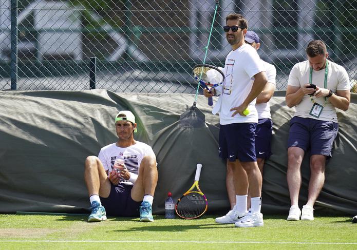 Rafael Nadal (sentado) durante un entrenamiento previo al torneo de Wimbledon, el martes 21 de junio de 2022. (Adam Davy/PA vía AP)