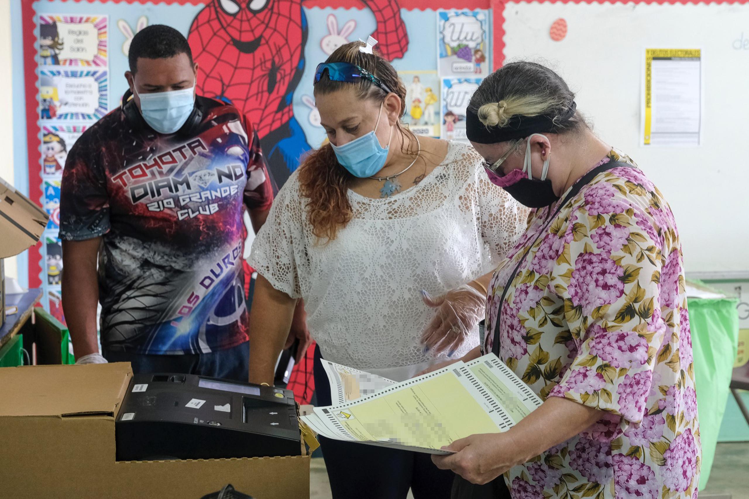 Maritza Estrada inserta la papeleta al votar en la escuela Guillermina Rosado en Loíza.
