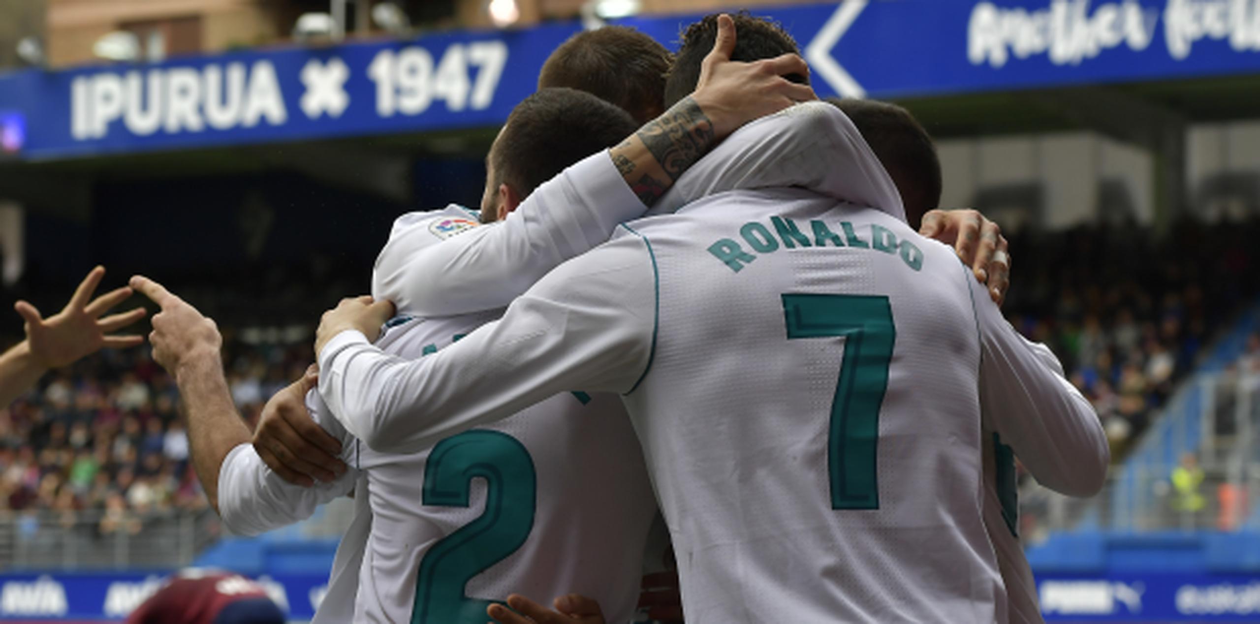 El jugador de Real Madrid, Cristiano Ronaldo, de espalda, festeja con sus compañeros tras anotar un gol contra Eibar en un partido por la liga española este sábado. (AP)