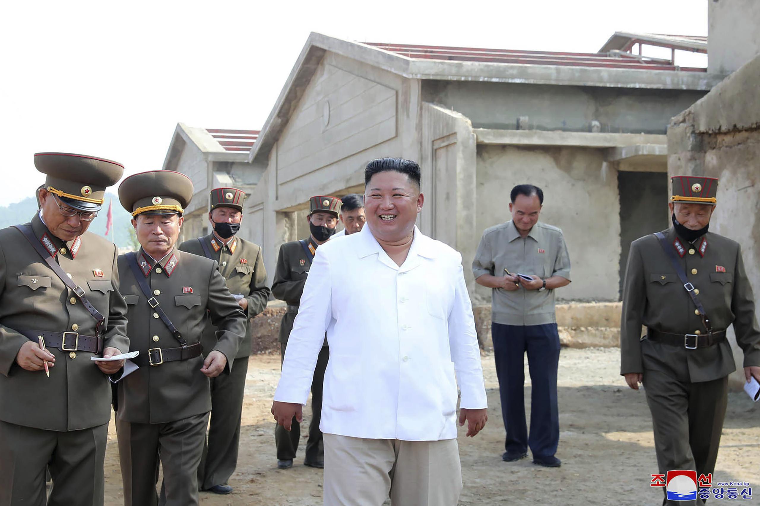El gobernante norcoreano Kim Jong Un, al centro, visita una nueva granja avícola en el distrito Hwangju, Corea del Norte