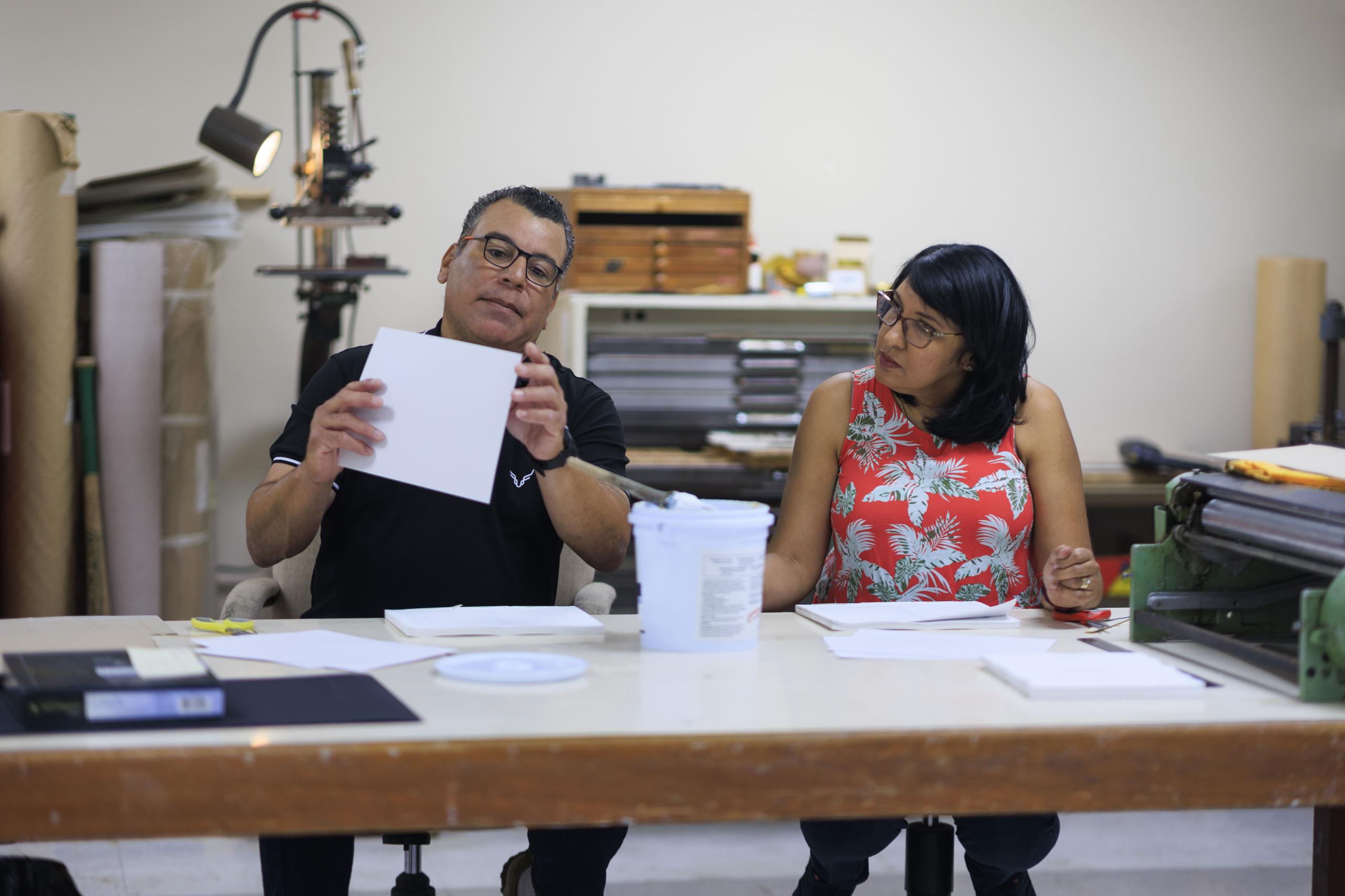 Javier Del Valle Pérez, encuadernador de Impresos RUM, se ha encargado de enseñar el laborioso arte técnico a Doris Milagros Torres, quien funge actualmente como auxiliar de imprenta.