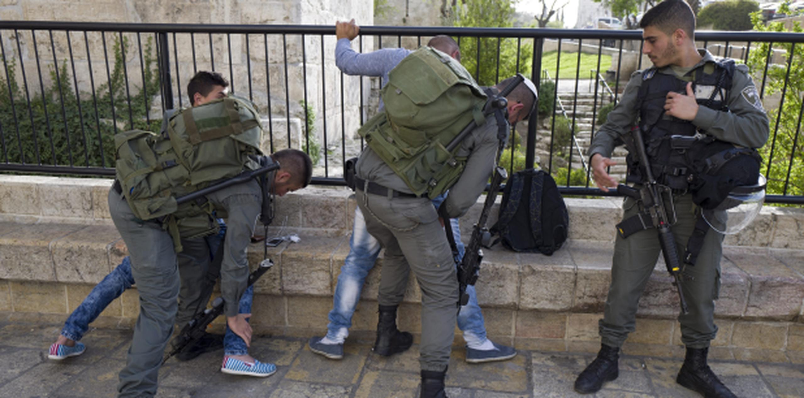 Agentes de seguridad israelíes examinan a dos jóvenes palestinos en la entrada de la Puerta de Damasco. (EFE)