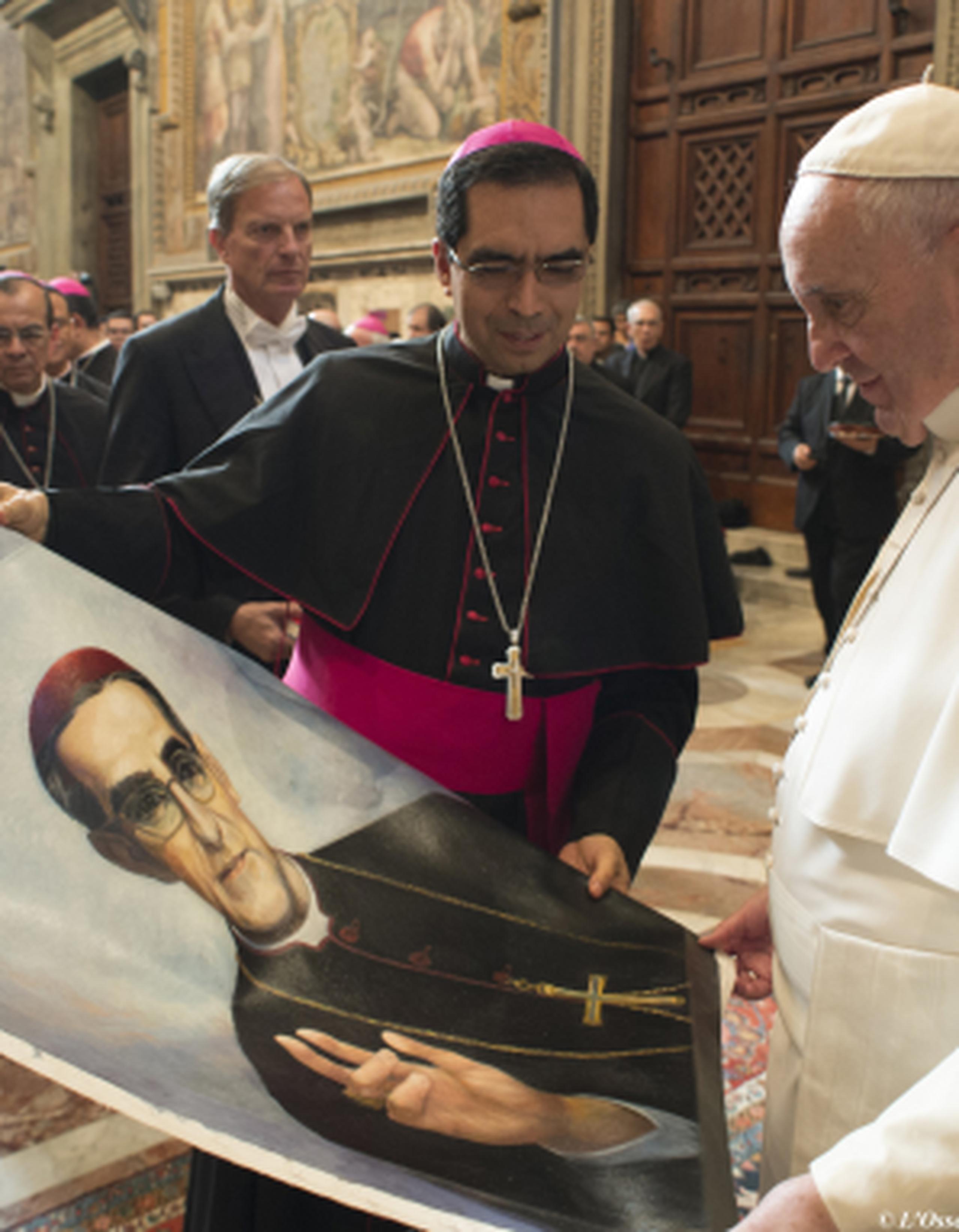 El papa Francisco observa un afiche del arzobispo Romero. (AP)