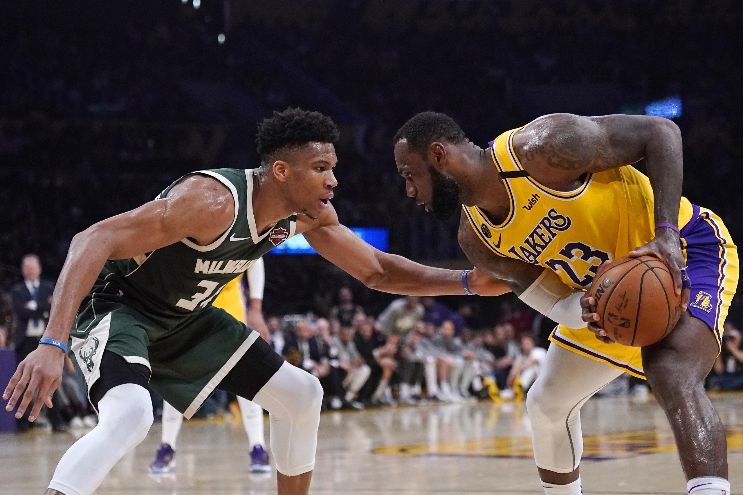 El jugador de los Lakers de Los Ángeles LeBron James intenta esquivar a Giannis Antetokounmpo, de los Bucks de Milwaukee, durante la segunda mitad del juego de la NBA que enfrentó a ambos equipos.