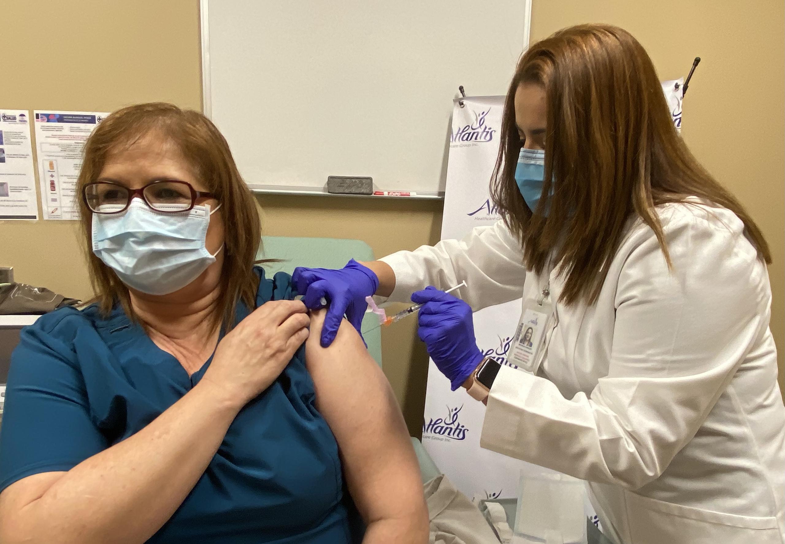 La enfermera Evelyn Figueroa recibió la primera dosis de la vacuna contra el COVID-19 de parte de Michelle Camacho.