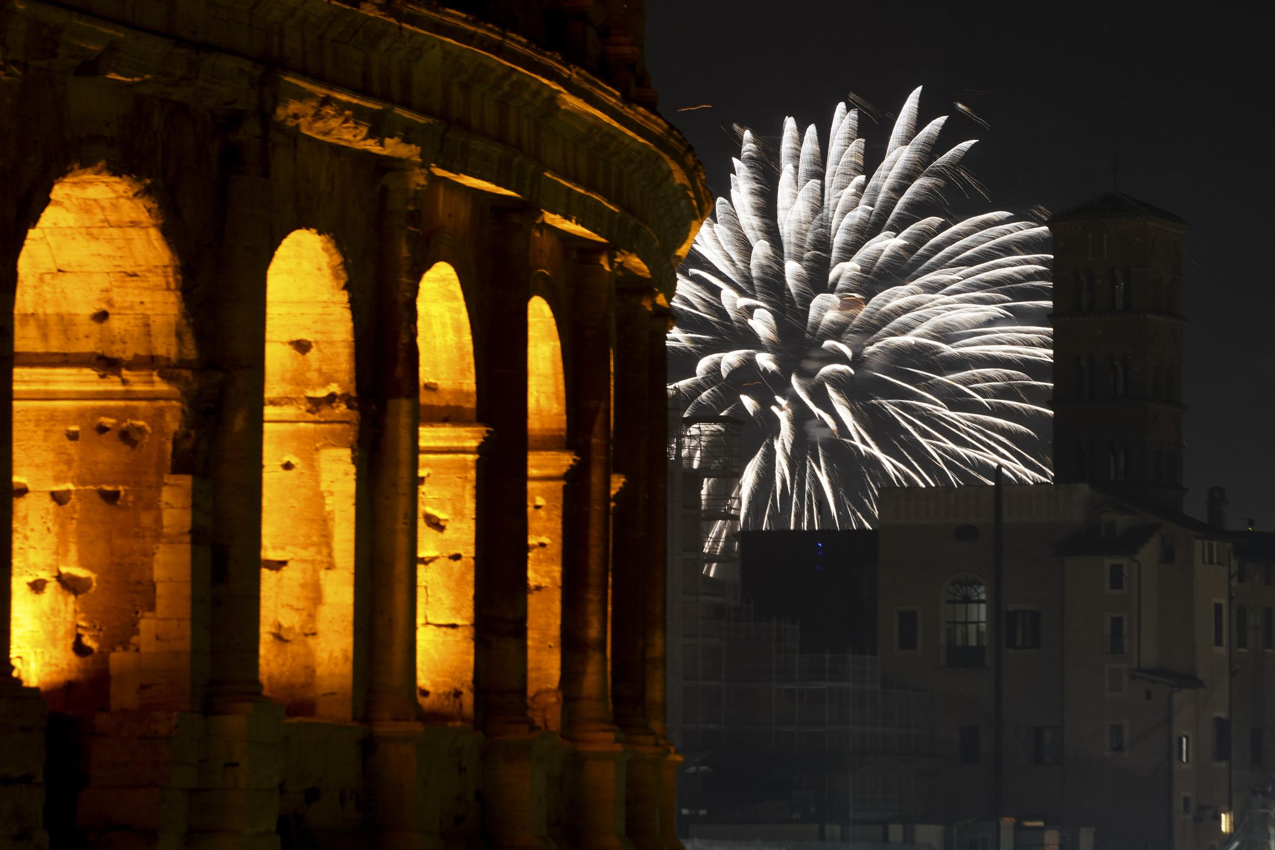 Fuegos artificiales por el Año Nuevo estallan cerca del Coliseo en Roma, Italia.