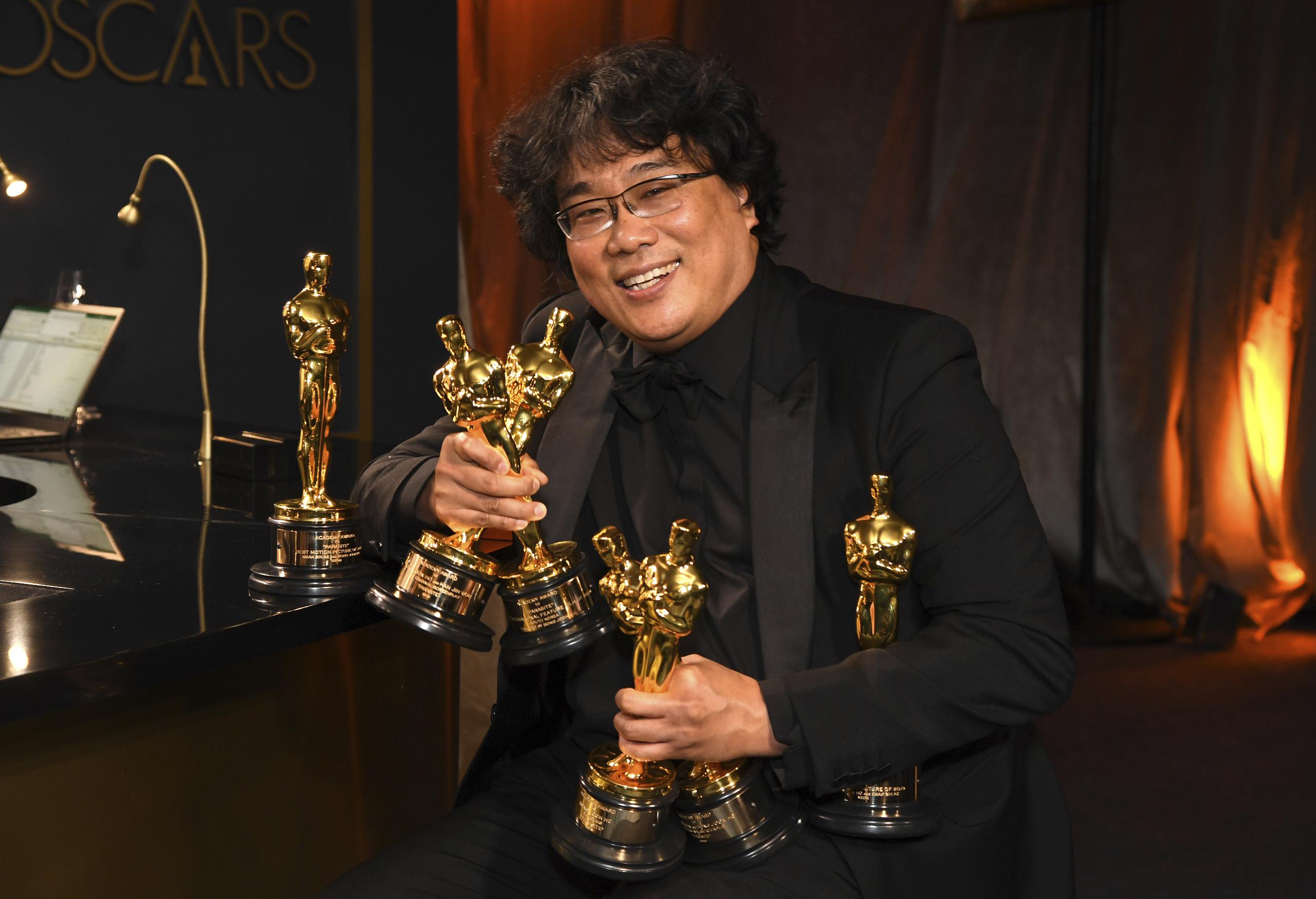 Bong Joon-ho sonríe mientras carga sus Oscars a mejor libreto original, mejor cinta extranjera, mejor director y mejor película.