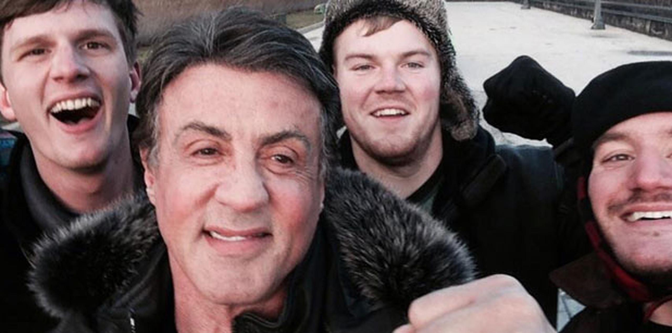 Stallone posó para el “selfie” con el trío de admiradores, con un puño arriba.  (AP/Peter Rowe)