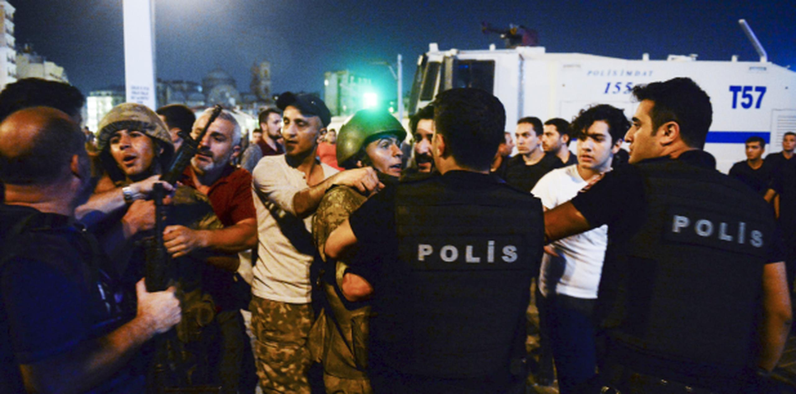 Ciudadanos entregan a la policía a varios militares golpistas a los que habían arrestado y despojado de sus armas en Estambul. (AP/Selcuk Samiloglu)
